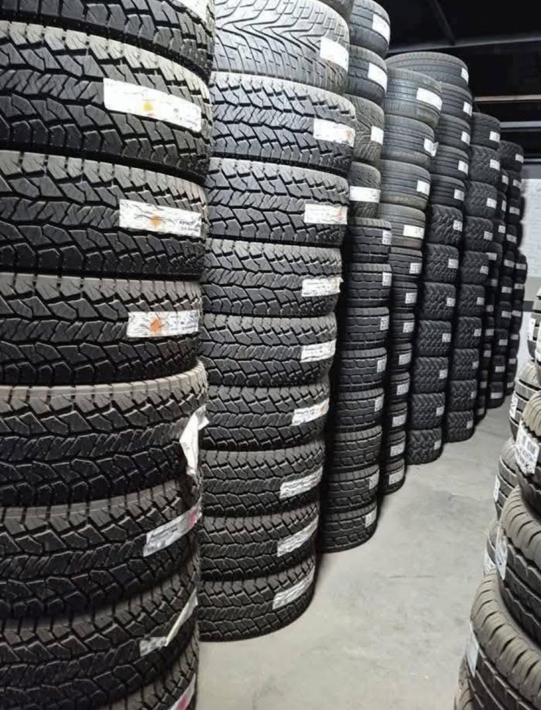 Stacks of new tires stored vertically in a warehouse.