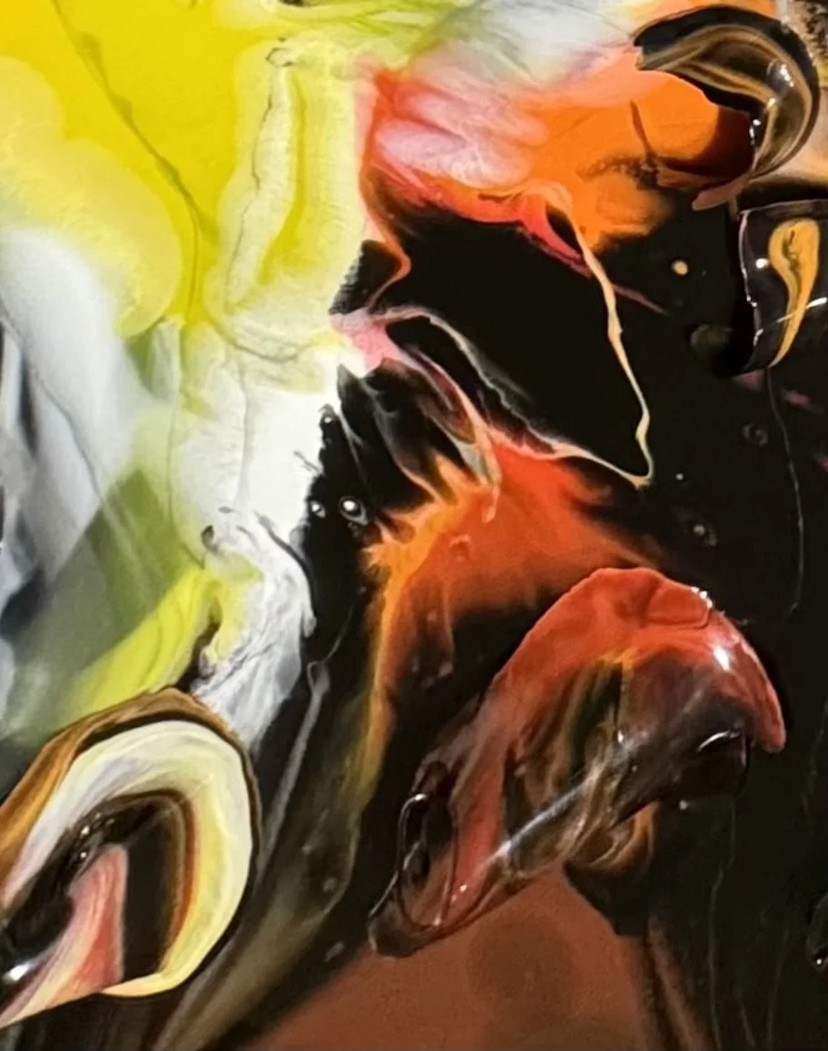 Abstract swirl of yellow, black, red, orange, and white paint with a glossy finish.
