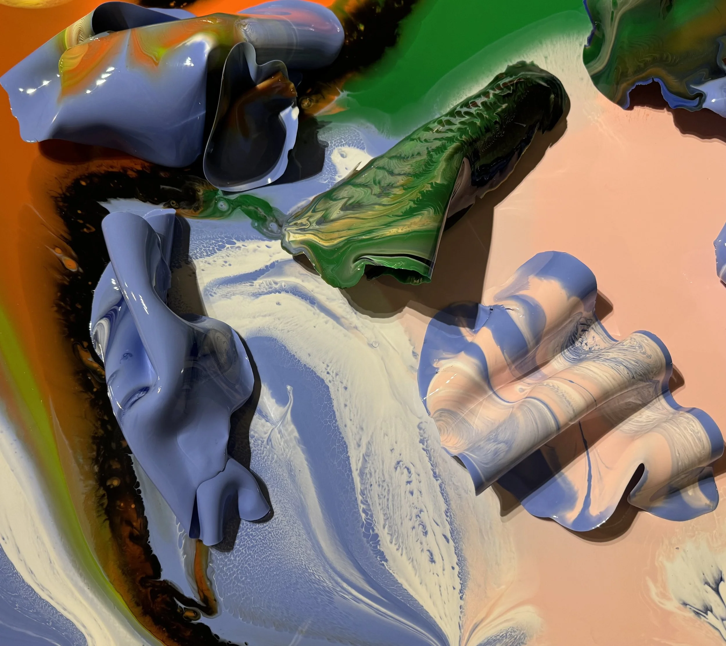 Abstract multicolored paint splashes and swirling patterns in shades of blue, green, black, and peach.