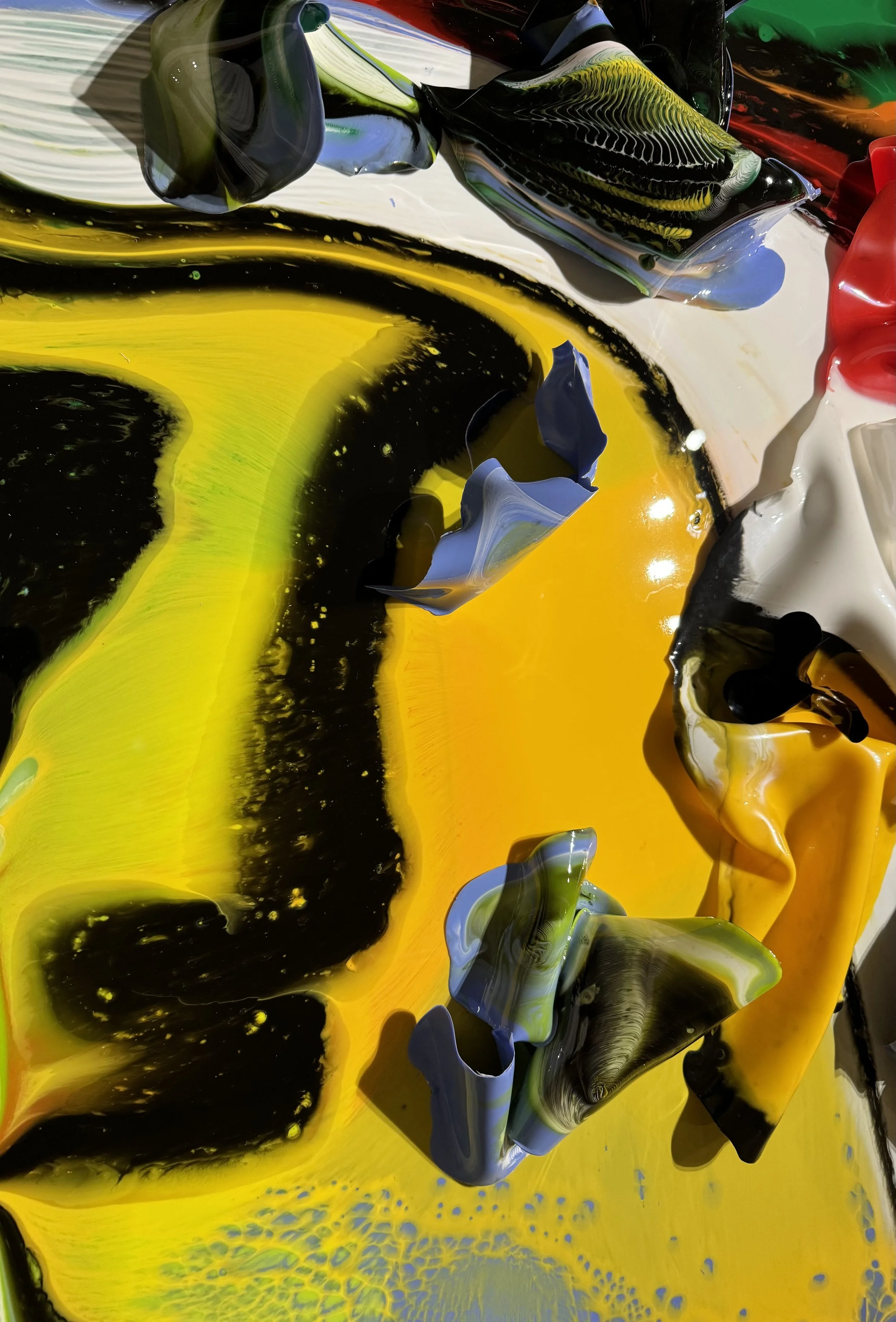 Abstract colorful paint swirls and splashes in yellow, black, white, blue, green, and red.