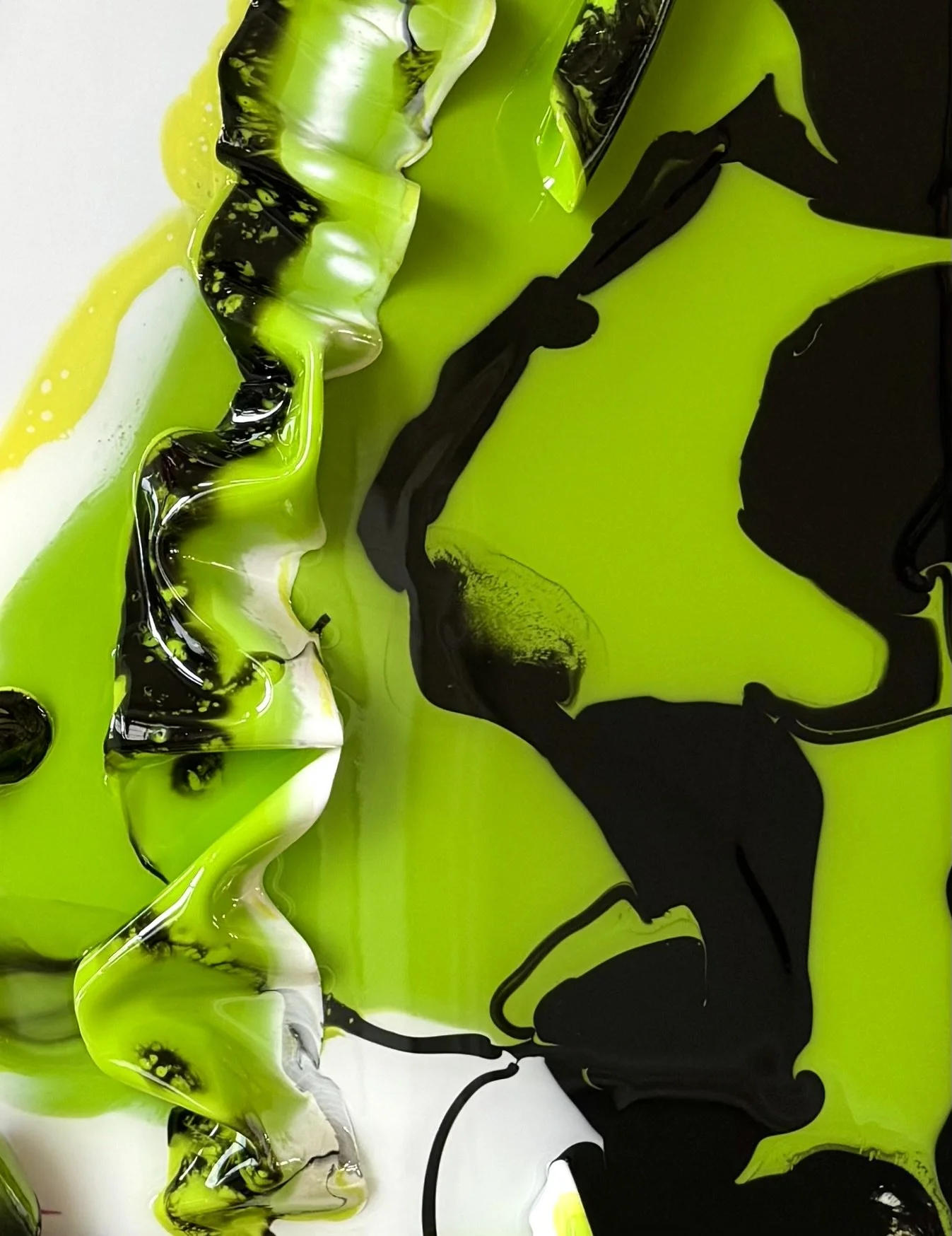 Abstract fluid art featuring swirling black, bright green, white, and yellow colors.