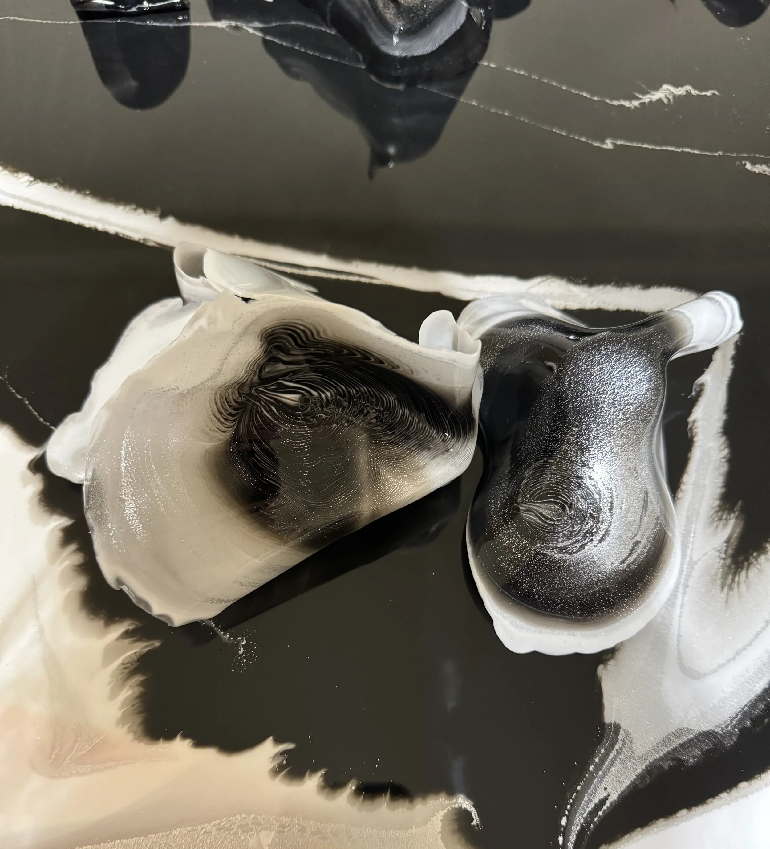 Abstract black and white ink art with swirling patterns and fluid shapes.