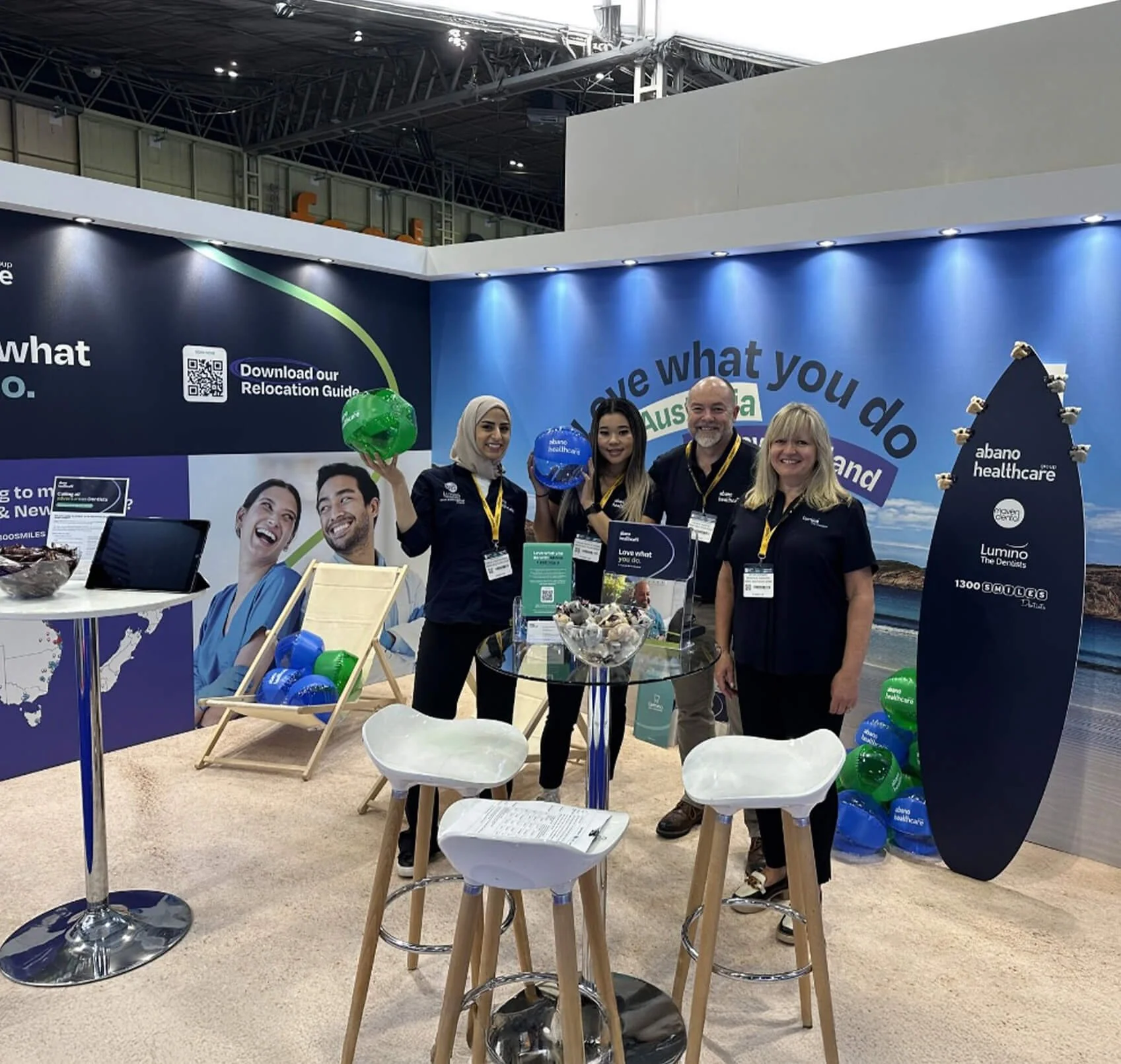 Abano Healthcare team at an international healthcare recruitment event, standing in front of a branded booth designed by Pronto Studio, featuring the ‘Love what you do’ campaign visuals and promotional materials
