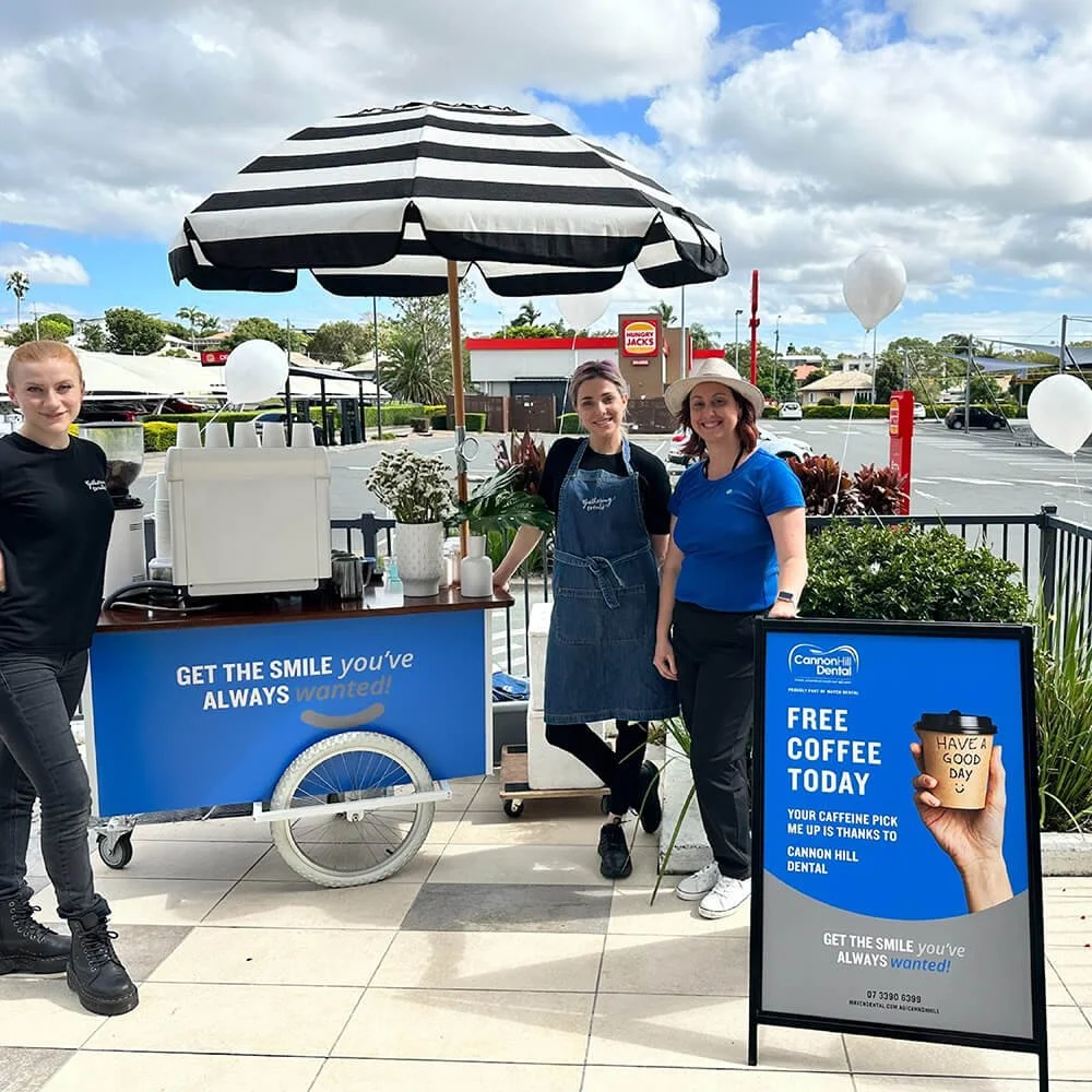 Cannon Hill Dental staff and barista team standing behind the mobile coffee cart during a local brand activation event.
