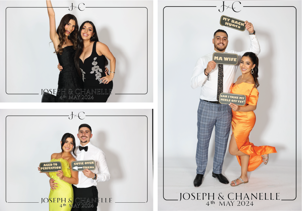 Photo booth setup with lighting equipment, props on a table, and a backdrop in a room with patterned carpet and vertical window panels.