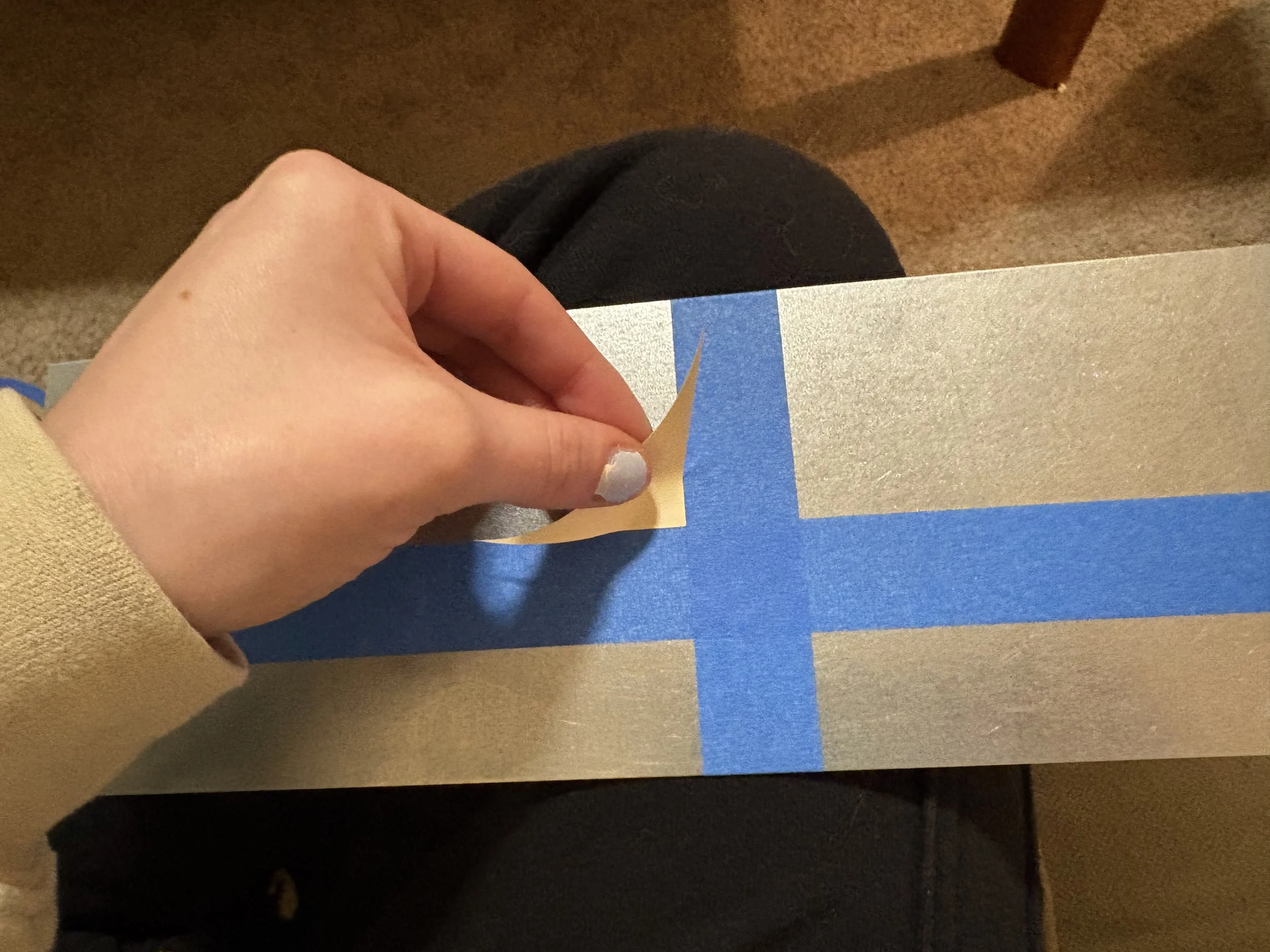 Step two of application: align the straight edge of the sticker with the jig.