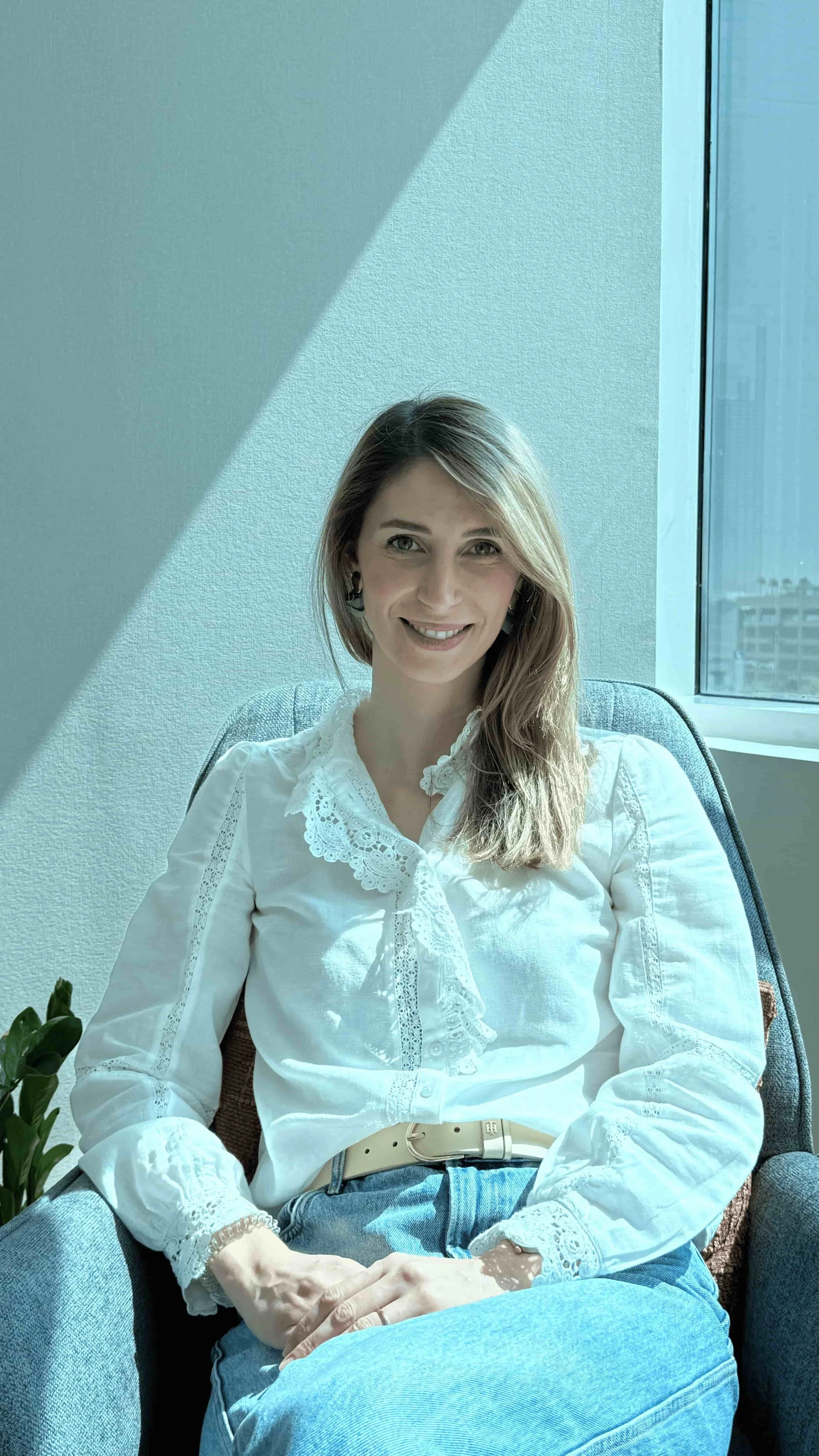 Rita Figueiredo, Peninsula's Psychologist and Director, sitting in a chair facing the photo.