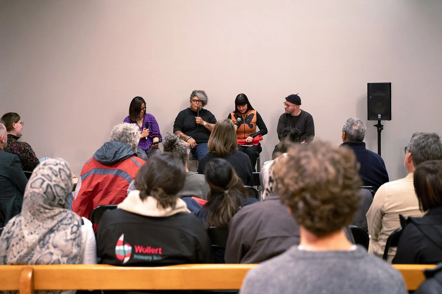 A panel of four diverse people, sitting on chairs in a room at Balam Balam Place Brunswick, speaking into microphones for The Atlas of Belonging. An audience faces them, ahead of a series of group activities exploring belonging in public space.