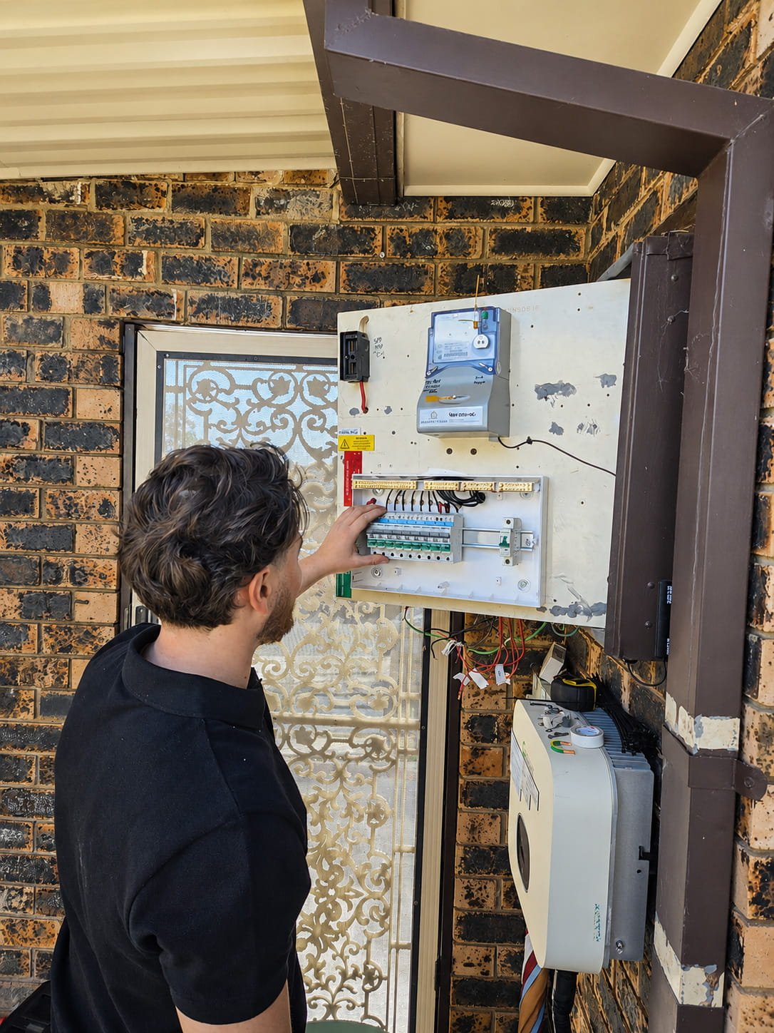 Ible Electrical technician working on an existing outdoor residential switchboard in Rosemeadow, Campbelltown area