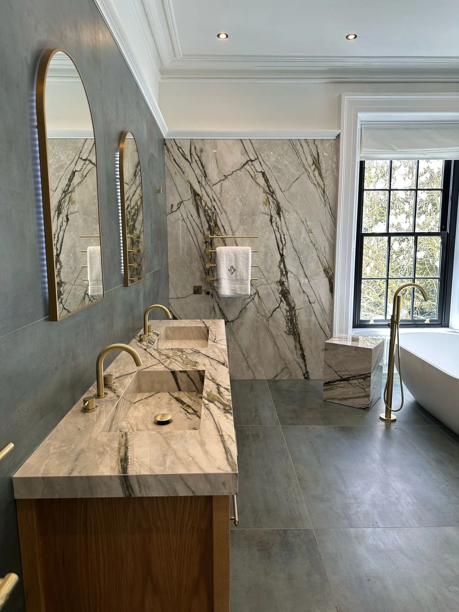 Large family bathroom. Double shower. Large format tiles. Recessed shelves. Mitred edges. Double vanity. Bespoke double basins. Illuminated mirrors. Free standing bath. Floor mounted bath tap.