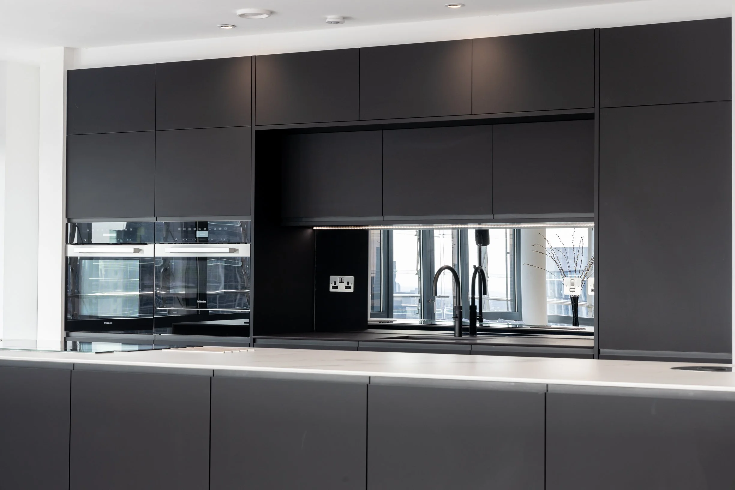Penthouse apartment kitchen and bathrooms. Large kitchen island. Integrated island hob. Double oven. Concealed downdraft extractor fan.