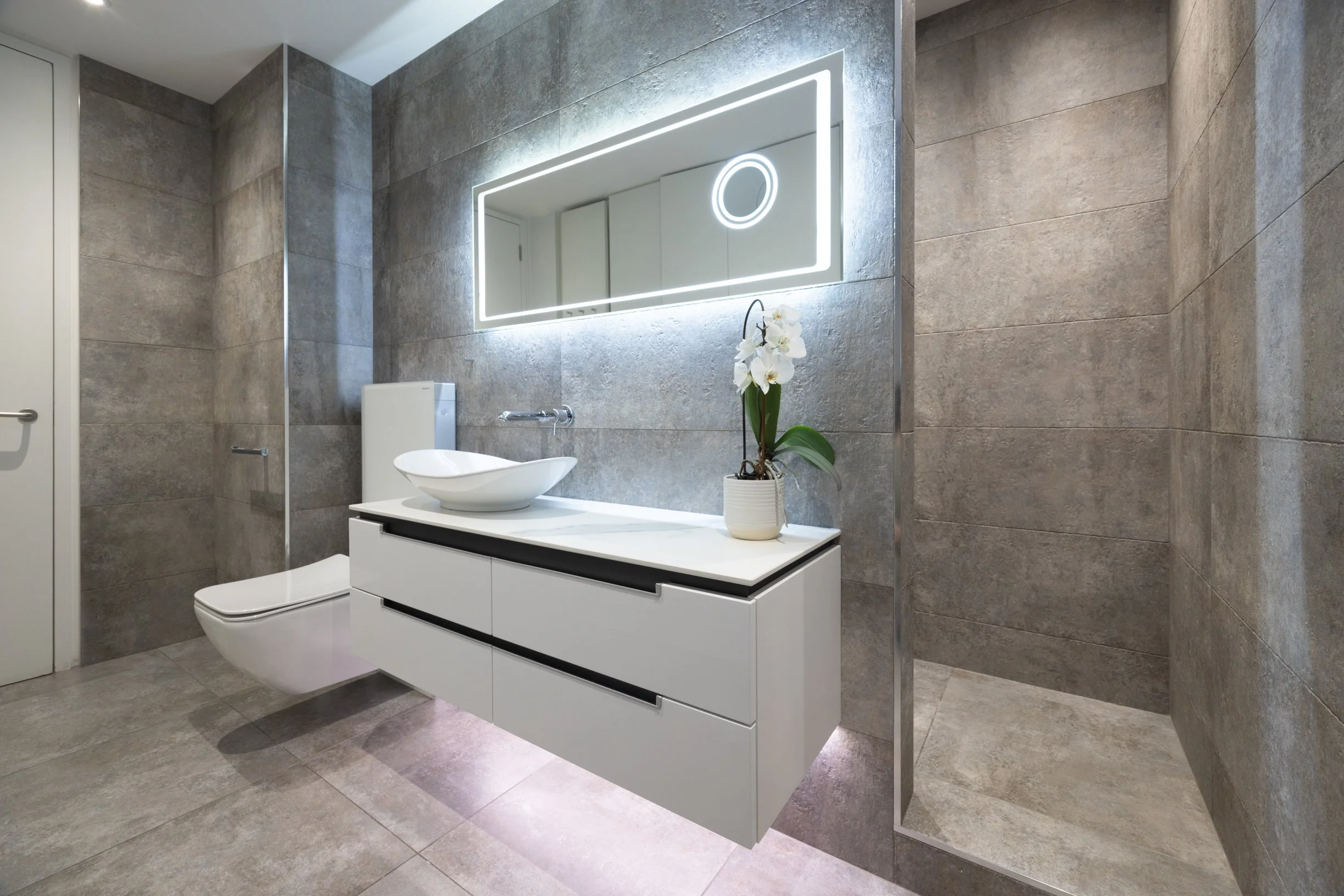 Penthouse apartment kitchen and bathrooms. Large kitchen island. Integrated island hob. Double oven. Concealed downdraft extractor fan. Freestanding bath. Large format tiles.