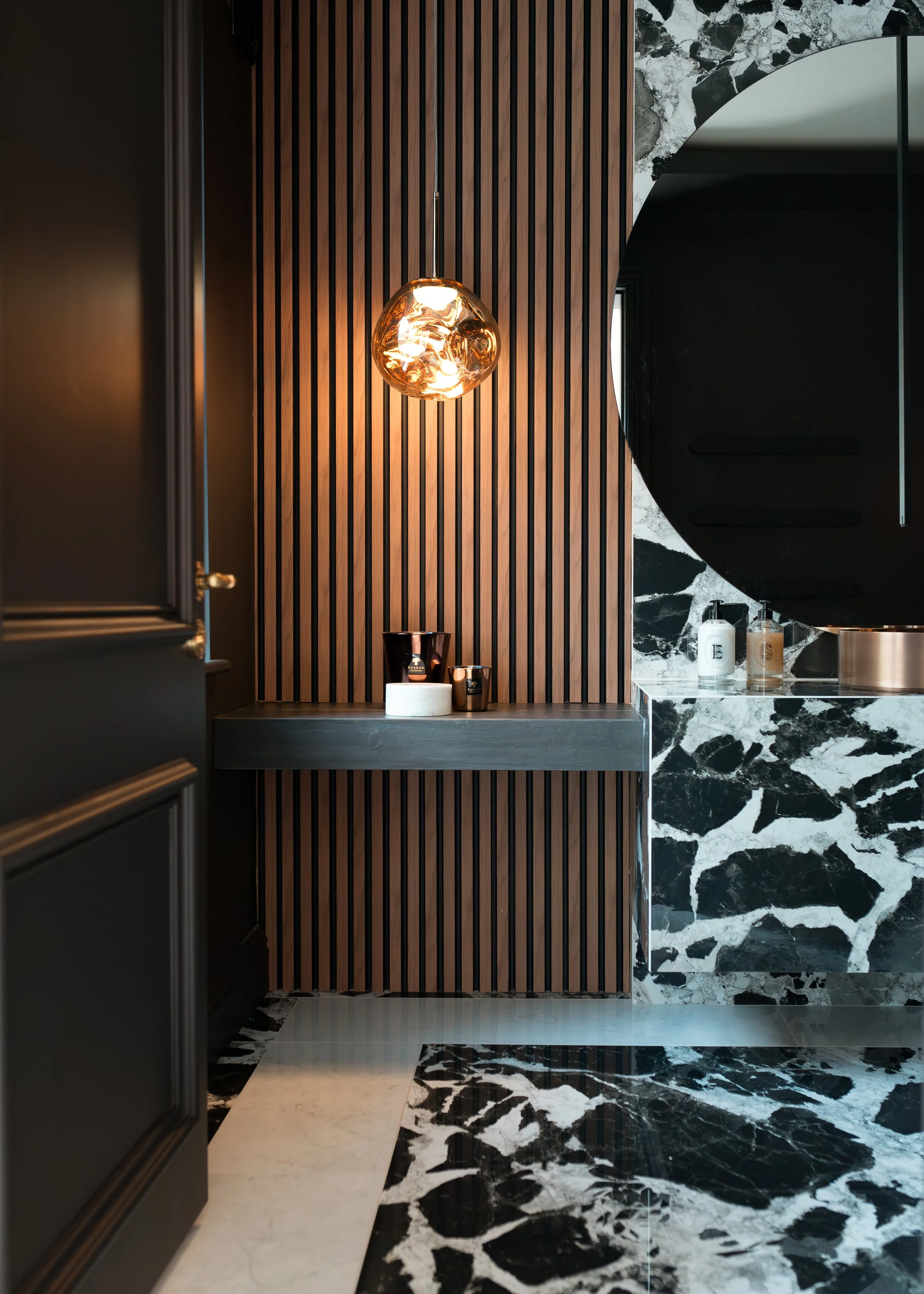 Powder room. Large format cow print tile. Bespoke vanity. Counter top basin. Large round wall mirror. Timber walls.