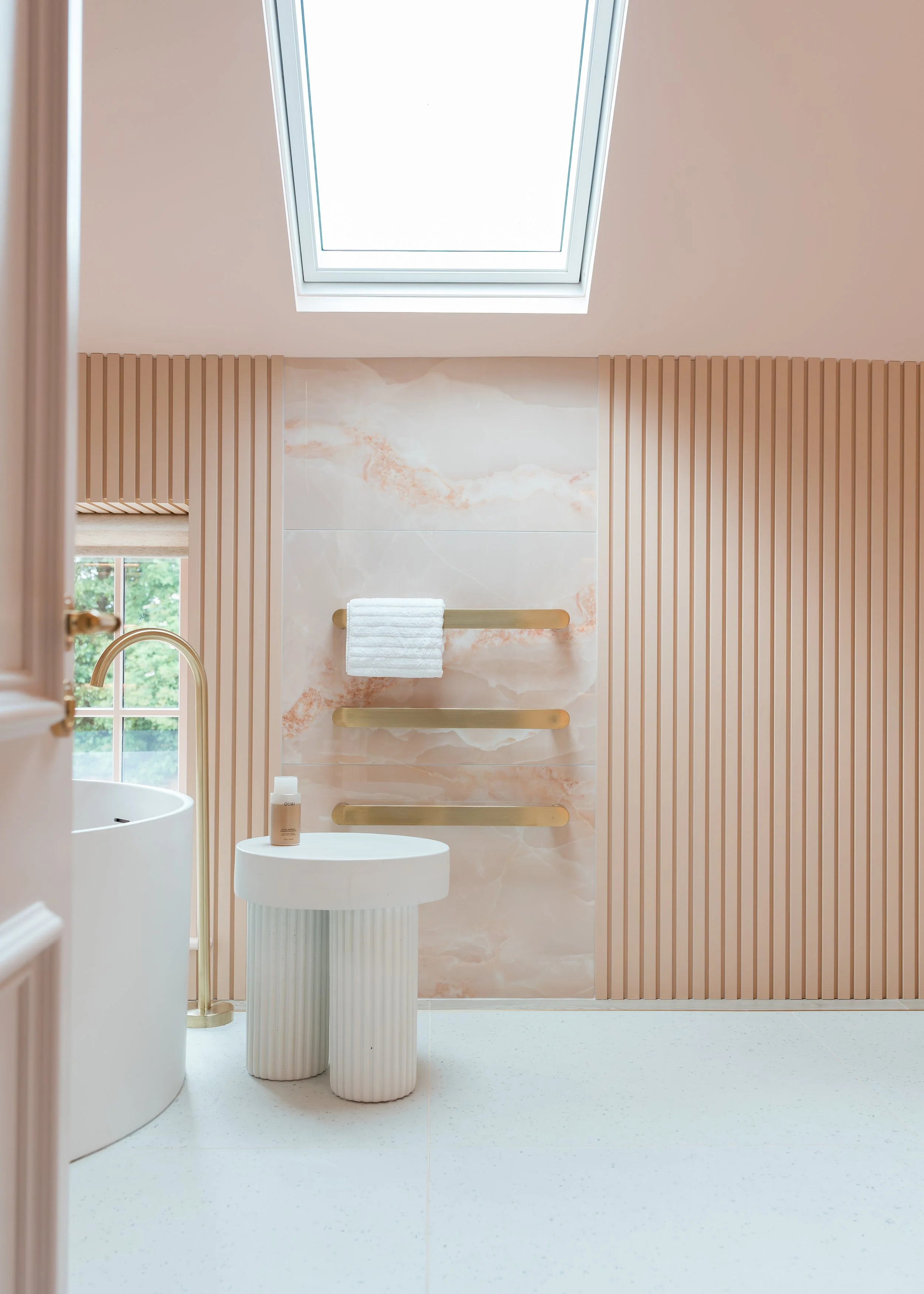 Pink onyx en-suite. Large format tiles. Flowing recessed shelves. Mitred edges. Bespoke vanity.