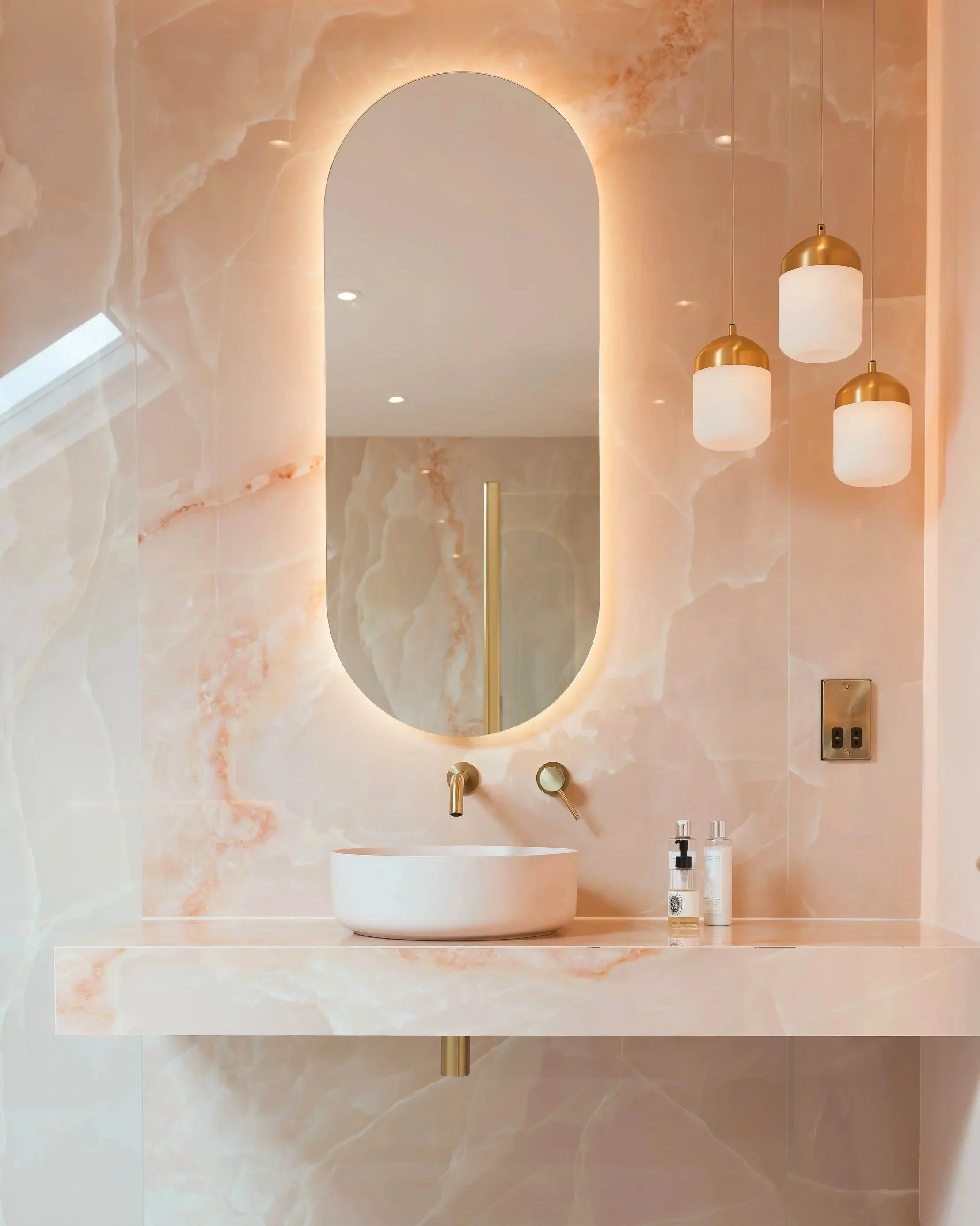 Bespoke onyx pink basin top and luxury large format tile installation by Lauzzo in a Manchester home renovation.