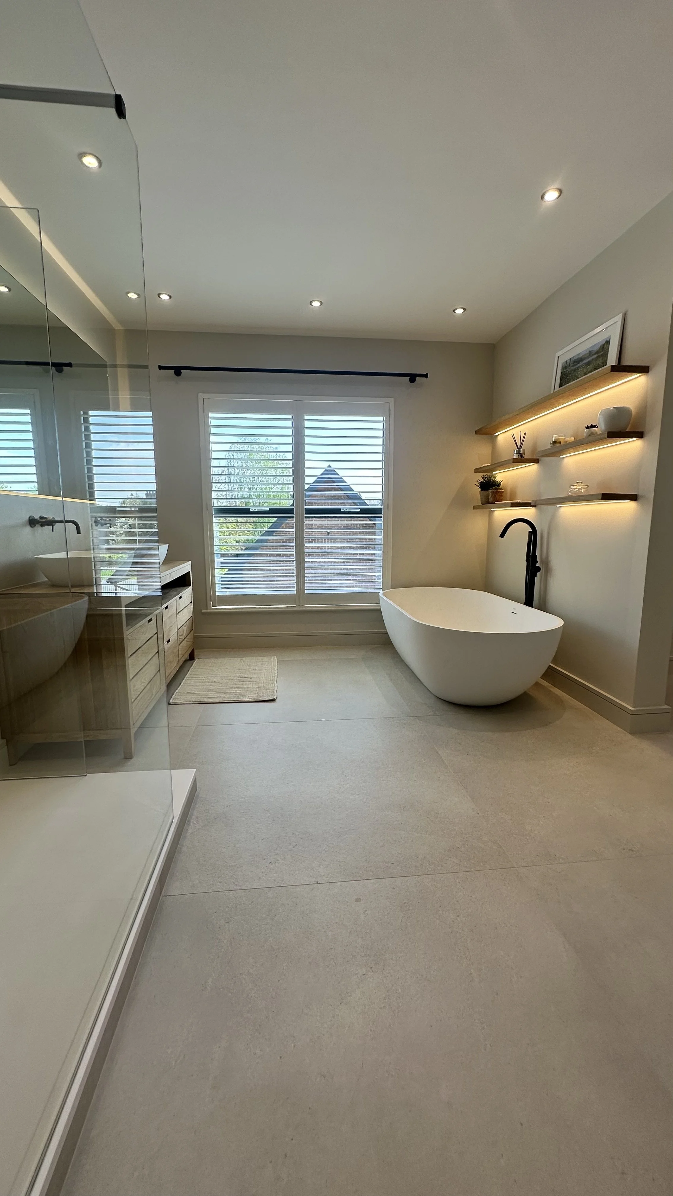free standing bath, large format tile, walk in shower cubicle with glass door and shower tray