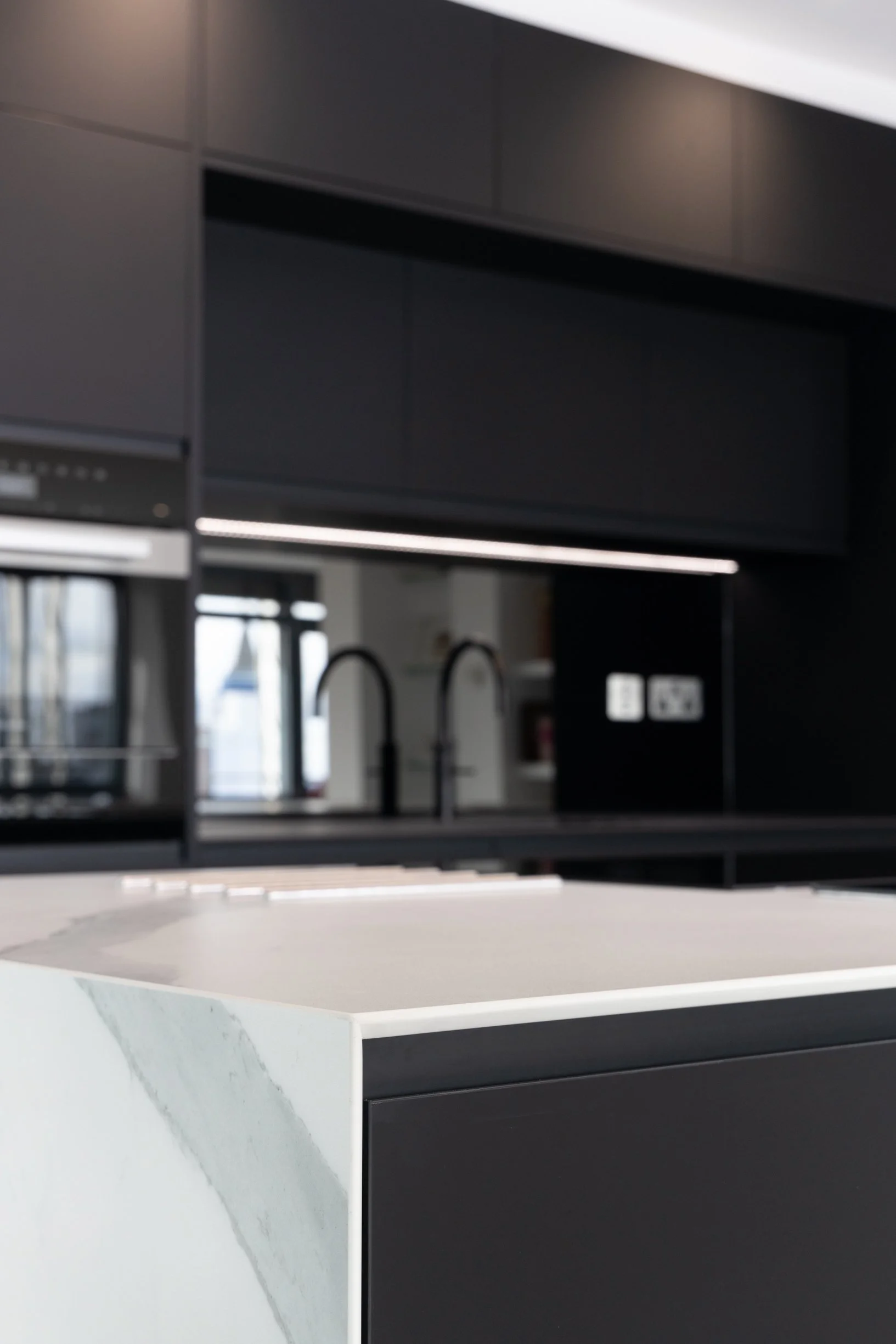 Penthouse apartment kitchen and bathrooms. Large kitchen island. Integrated island hob. Double oven. Concealed downdraft extractor fan.