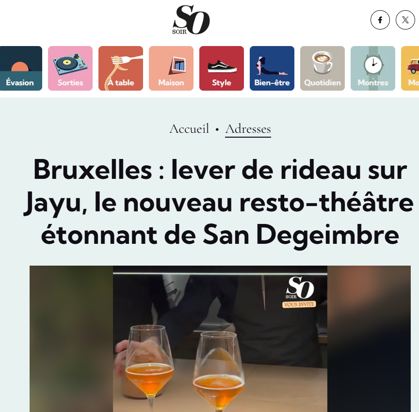 Deux verres à vin avec une boisson orange sur une table, avec une personne en arrière-plan