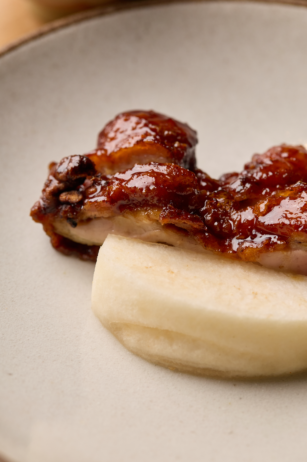 Poulet rôti avec sauce barbecue et purée de pommes de terre sur une assiette beige.