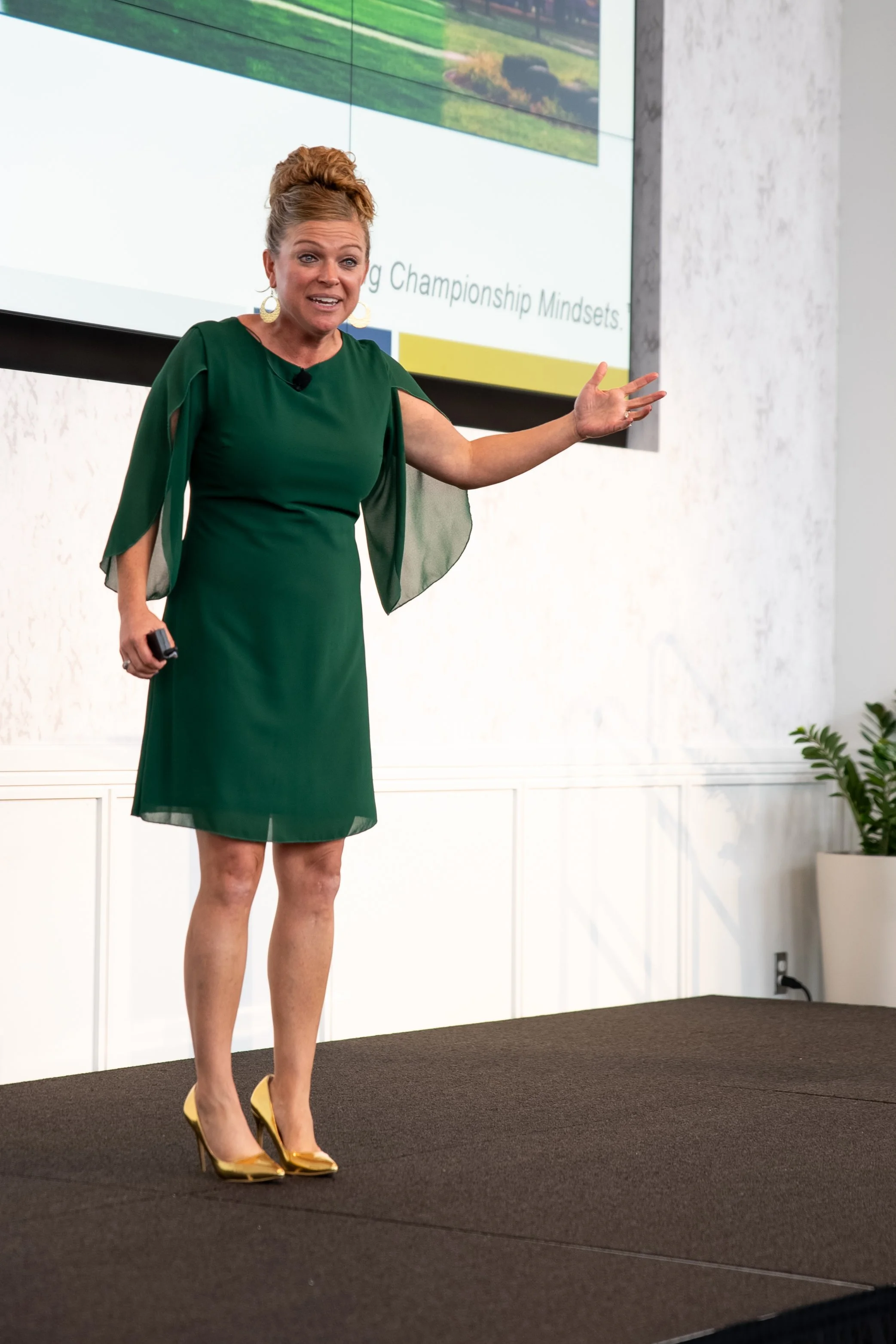 Person in green dress giving a presentation