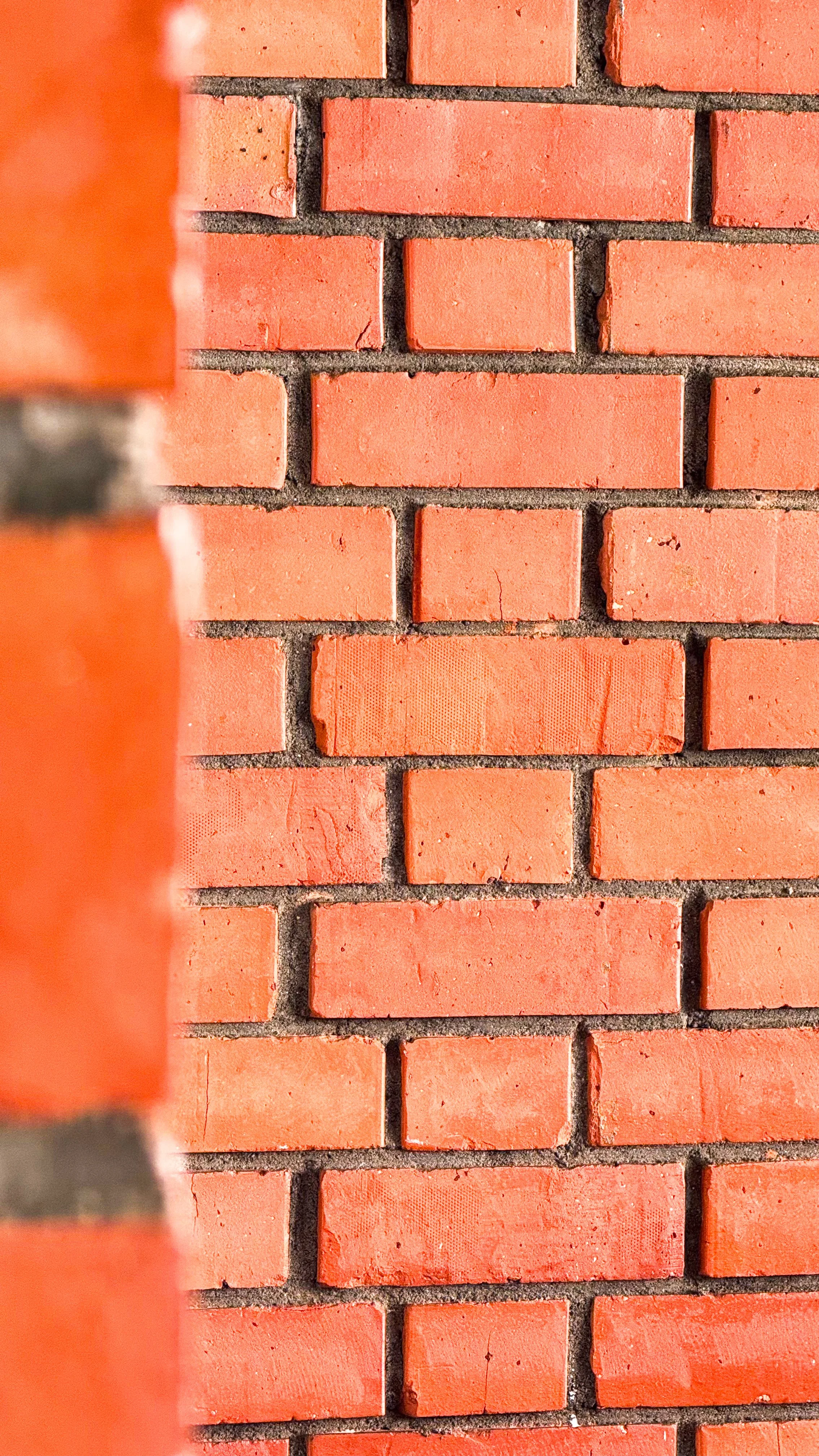 Close-up of a red brick wall with offset pattern and visible mortar joints.