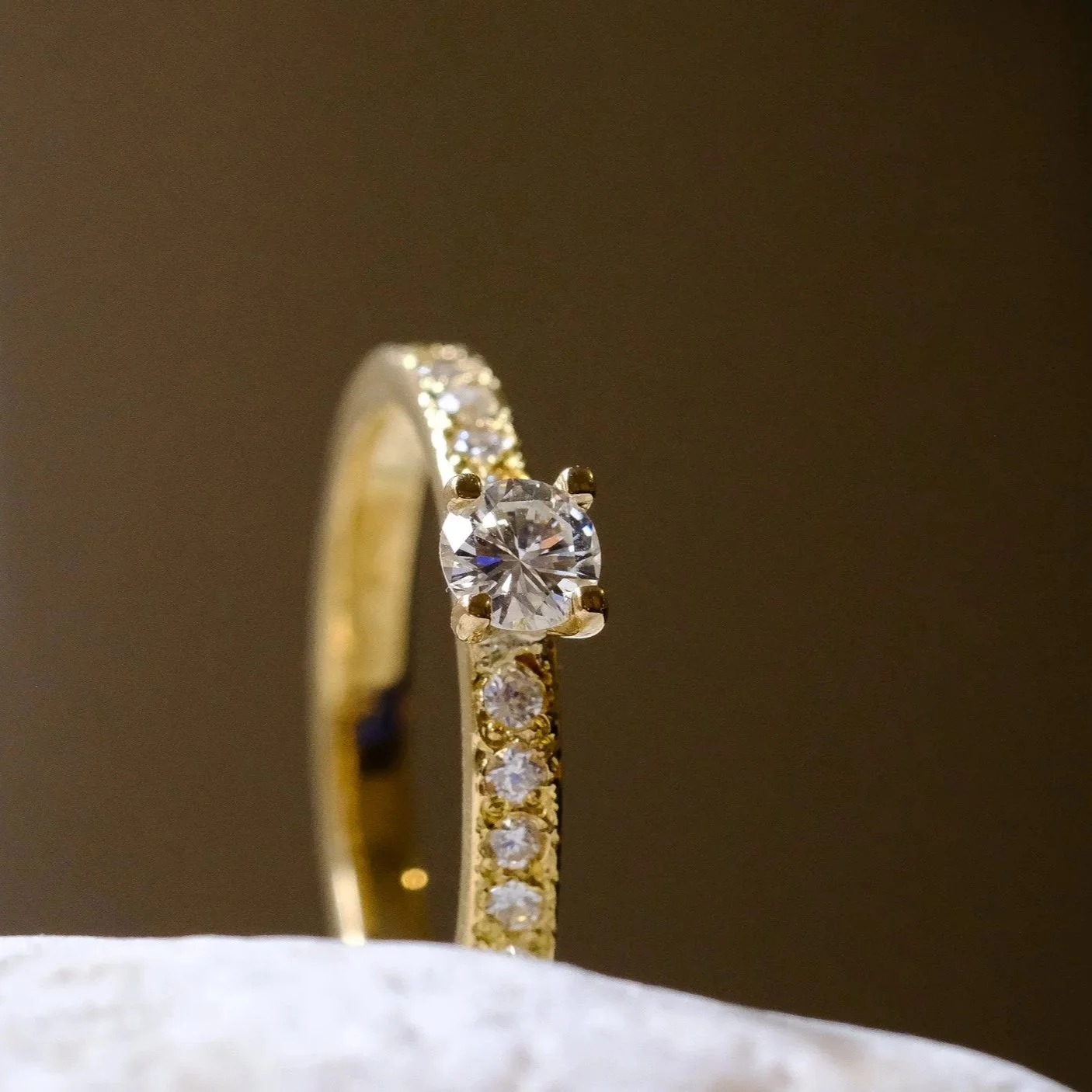 Verlovingsring in 18k goud met 1ct diamant en enkele extra kleine diamanten
