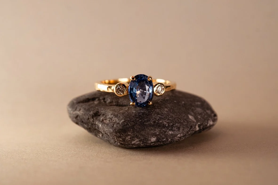 Handgemaakte 18k gouden ring met gesmede structuur afgewerkt met blauwe saffier en diamant