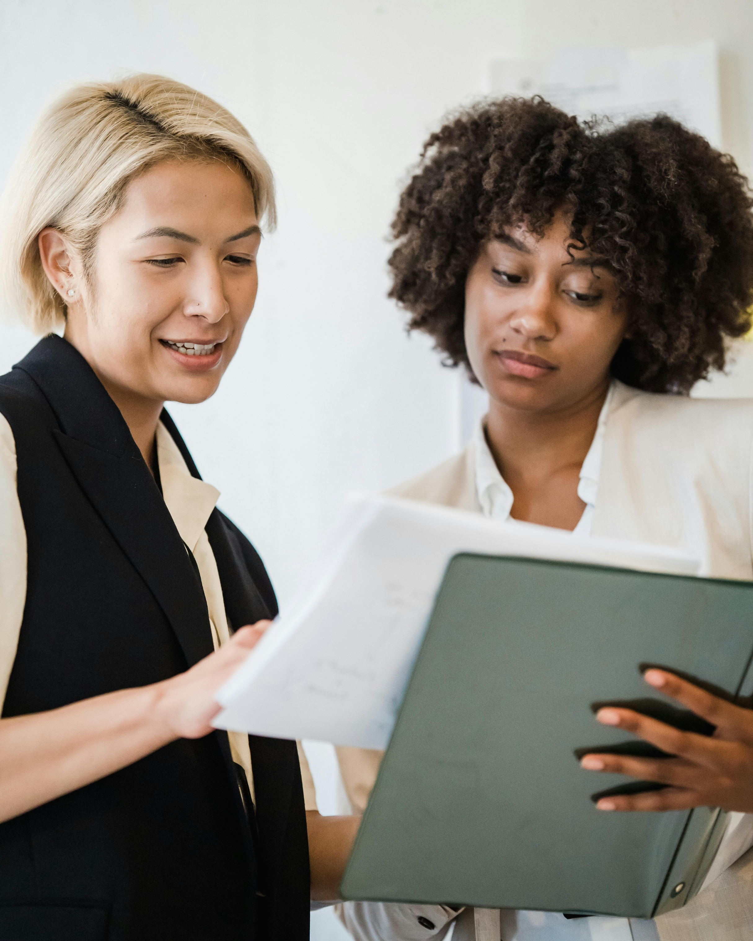 To personer diskuterer dokumenter i et kontormiljø.