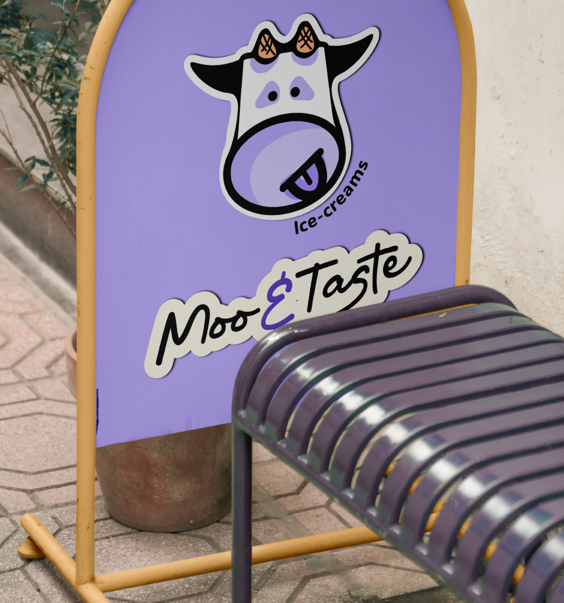 A purple outdoor sign advertising Moo & Taste ice creams with a cartoon cow face and a metal bench in front.