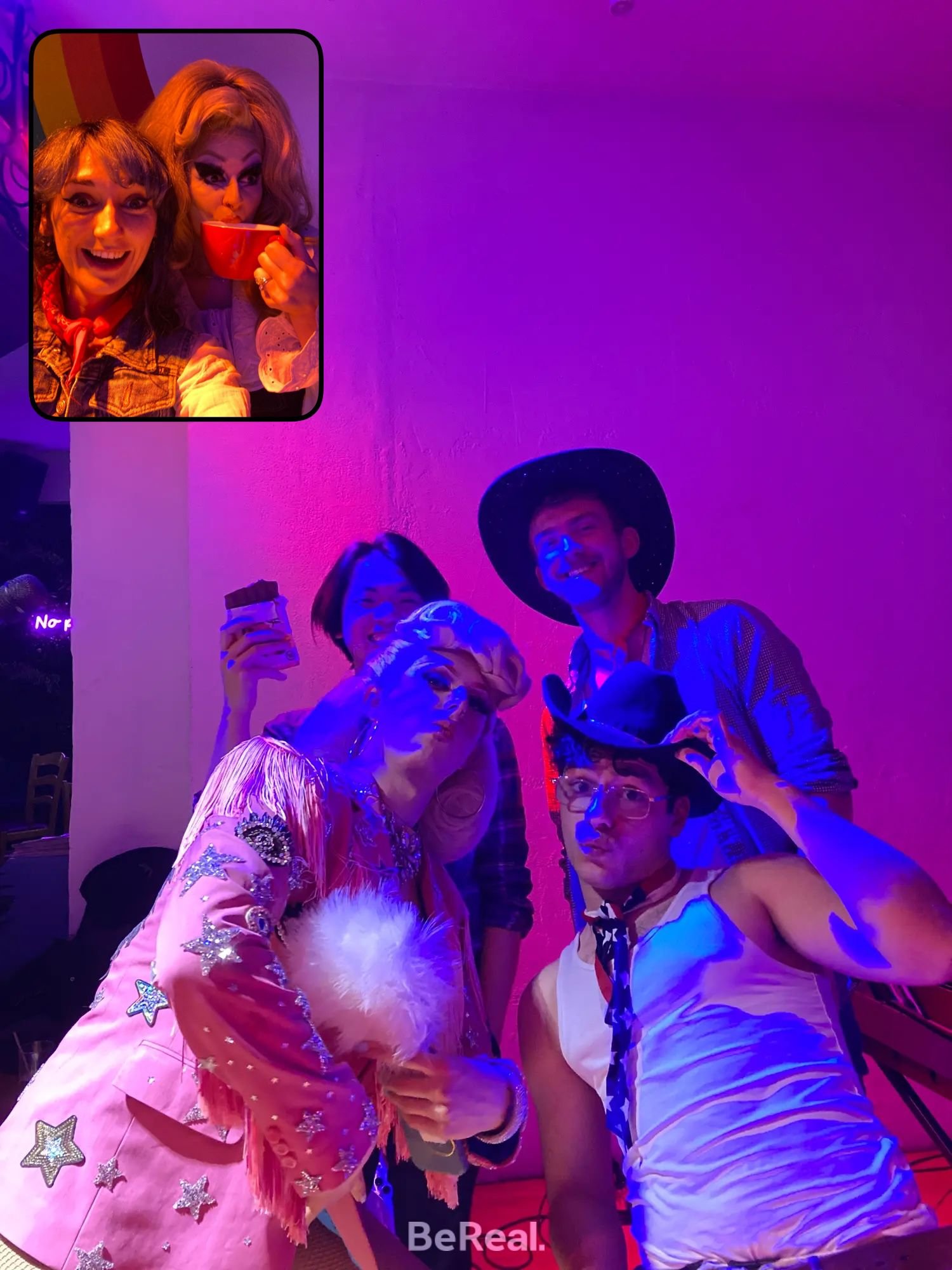 Group of people in colorful costumes and cowboy hats posing indoors with purple lighting; inset of two people smiling, one holding a red cup.