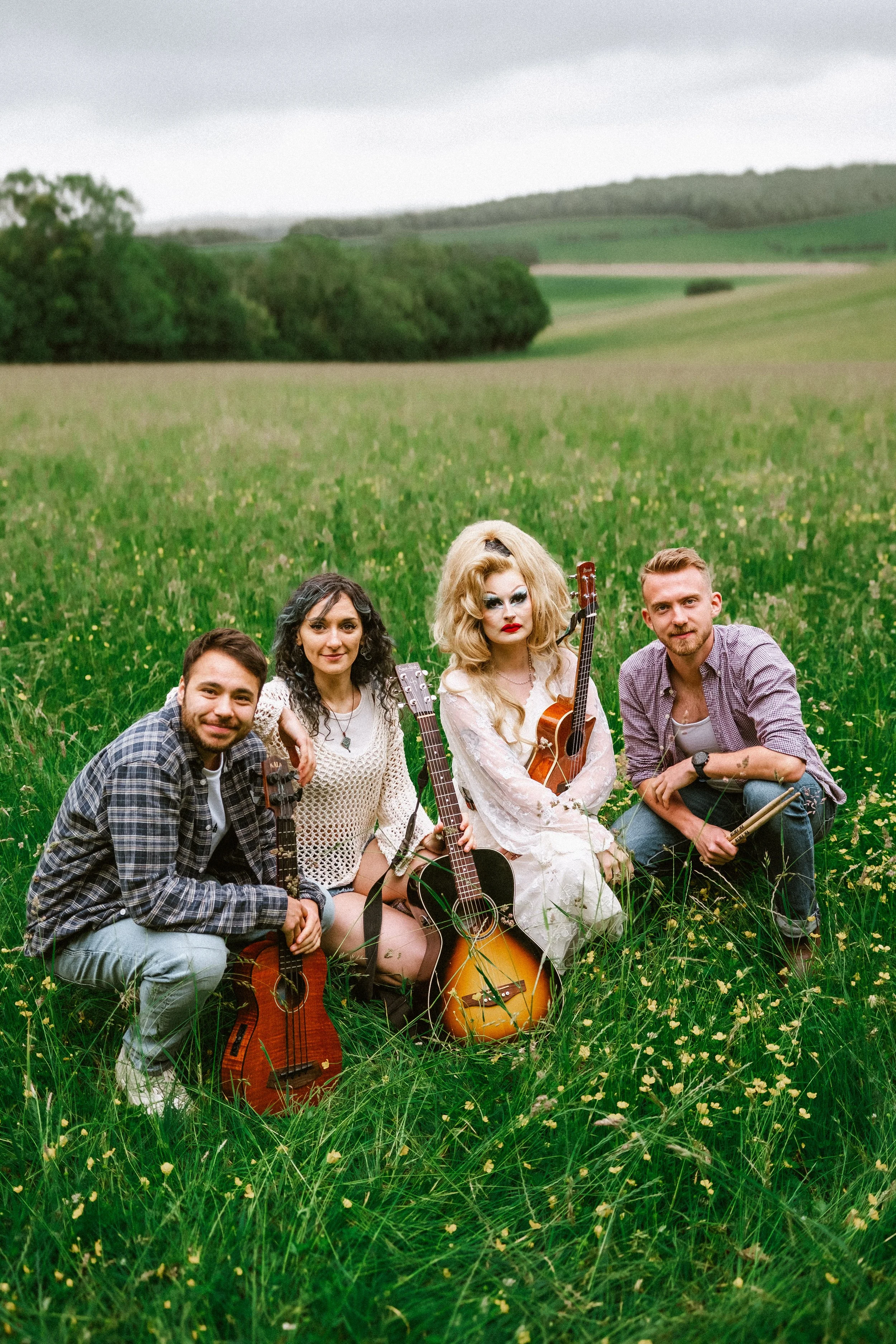 A band during an outside photo shoot, with drag queen Amber Sands in a blonde wig