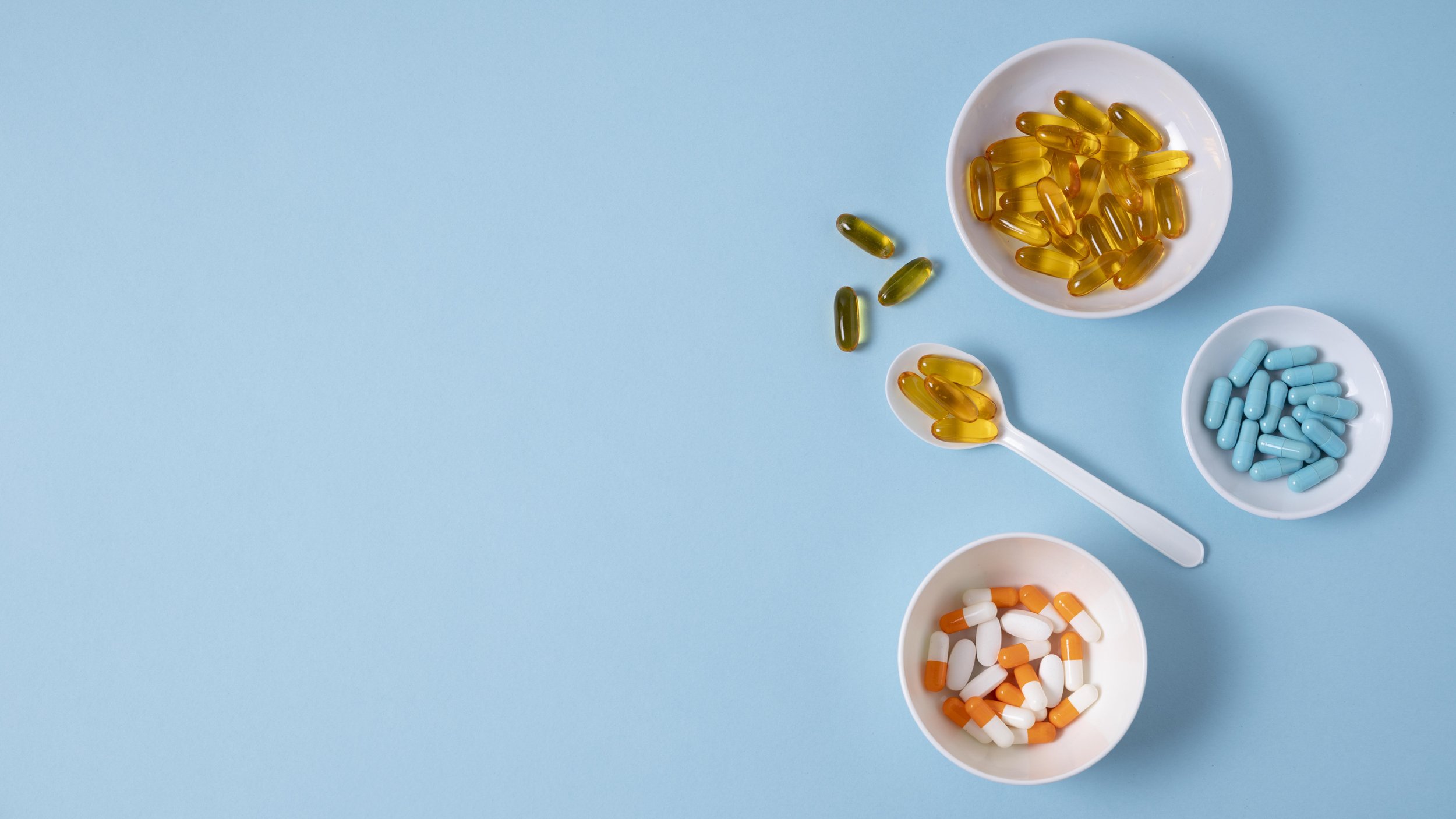 top views of pill in bowl and spoon, fish oil, supplements pill.