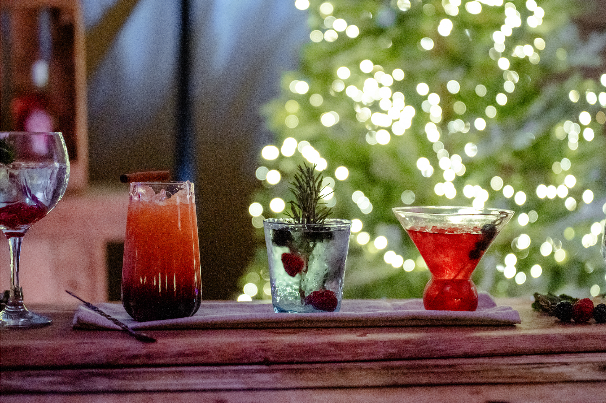 Festive cocktails with fairy light tree behind cocktail bar.png