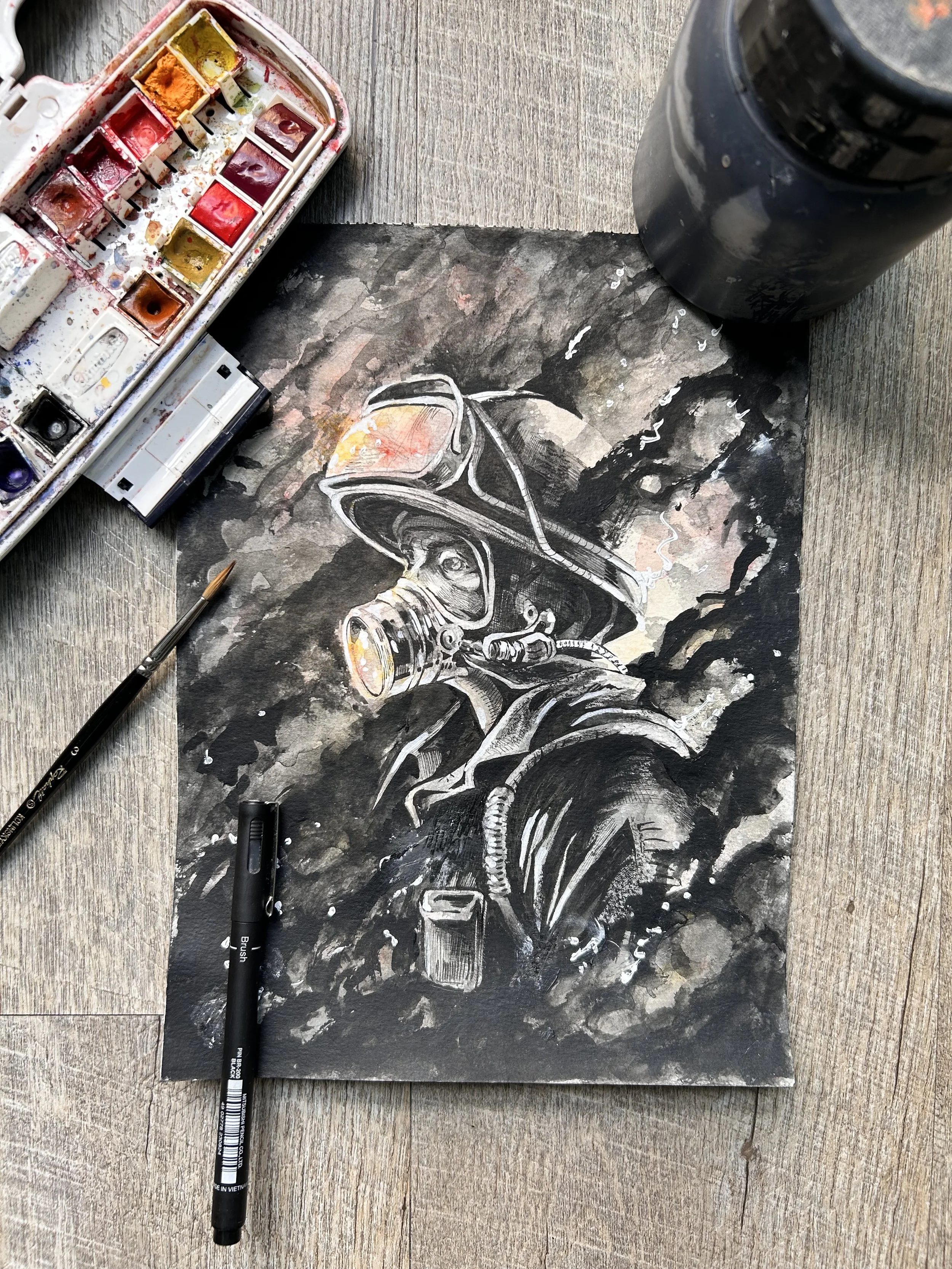 Une peinture à l'aquarelle représentant un casque de vélo. Sur la table, il y a une boite de peintures, un pinceau, un marqueur noir, et une bouteille noire.