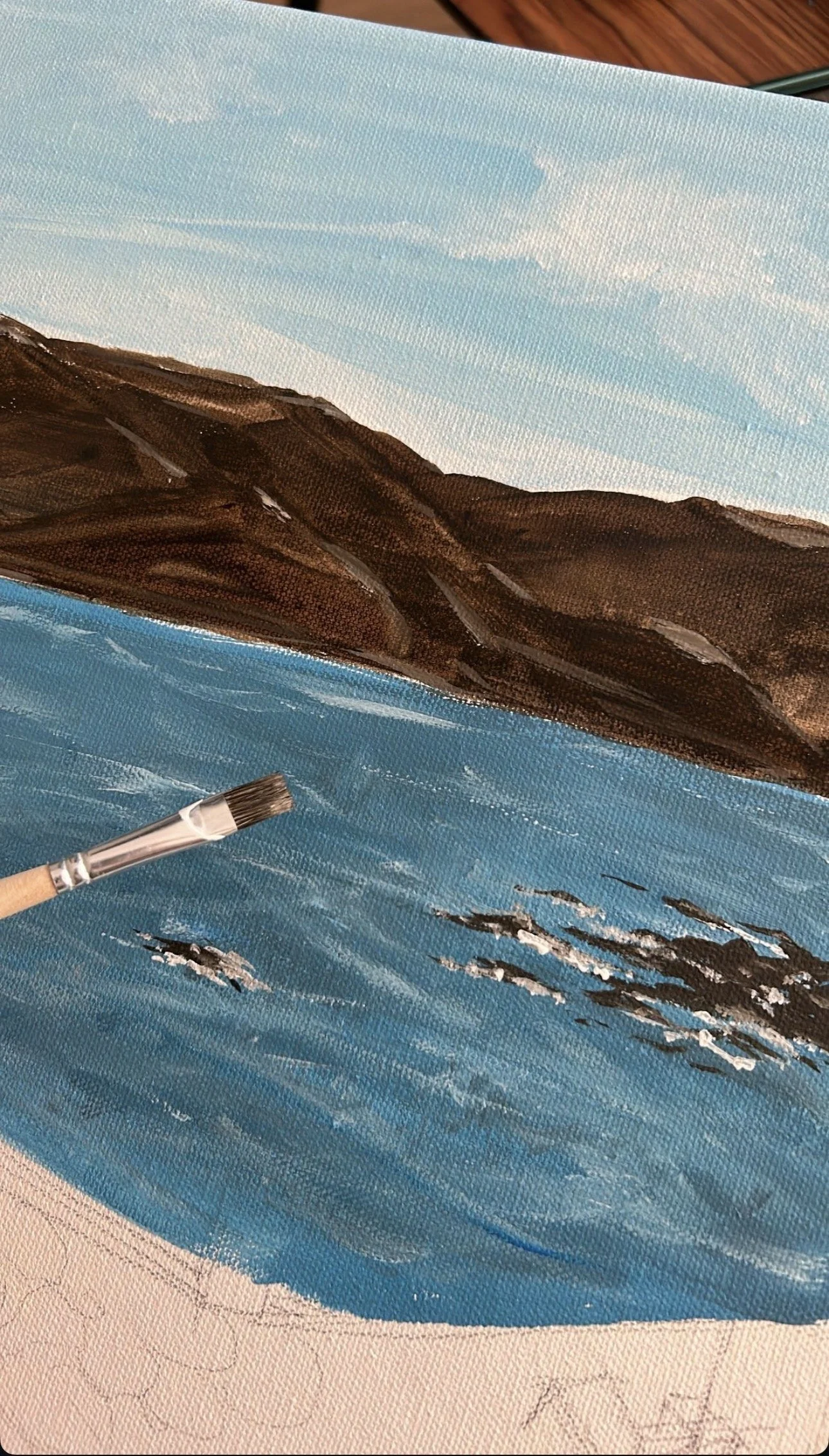 Une peinture en cours représentant un paysage de montagnes maritimes, avec un ciel bleu clair et des oiseaux volants dans le ciel, peint avec des coups de pinceau visibles.