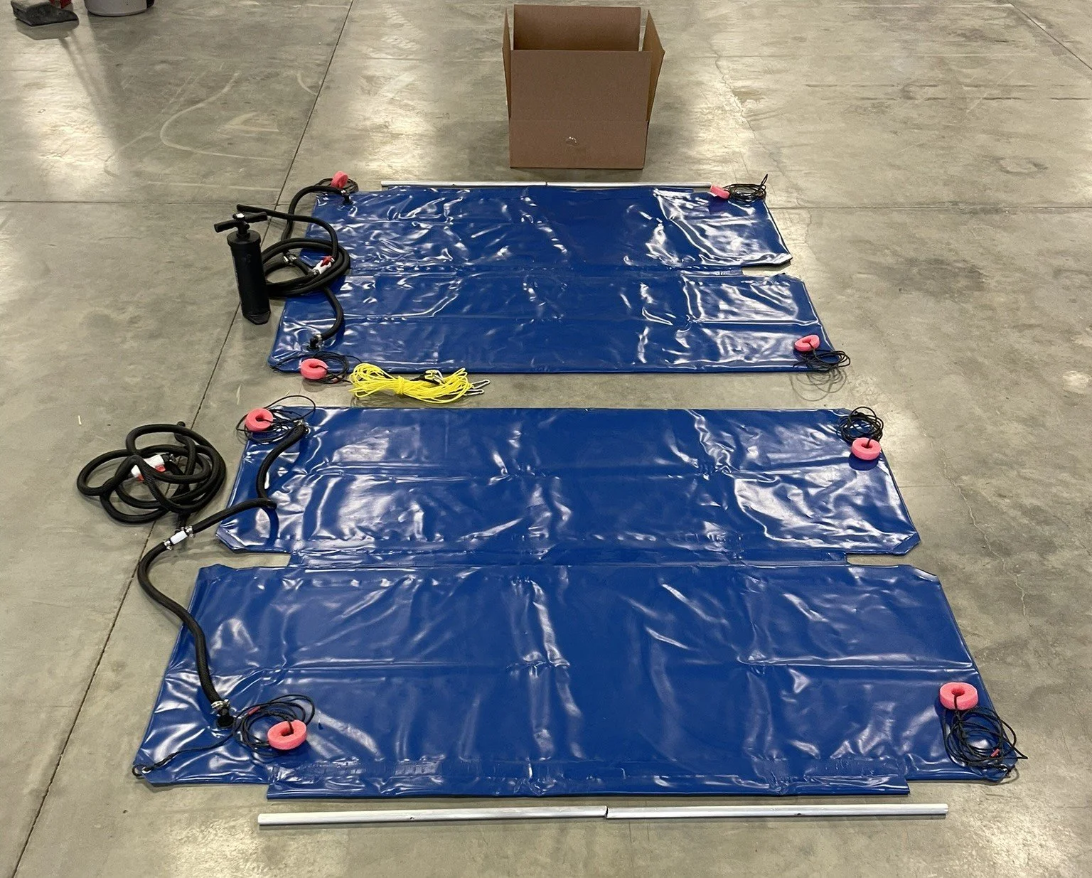 The contents of the Marina Mate kit: two bags, a pump, and accessories on a concrete floor