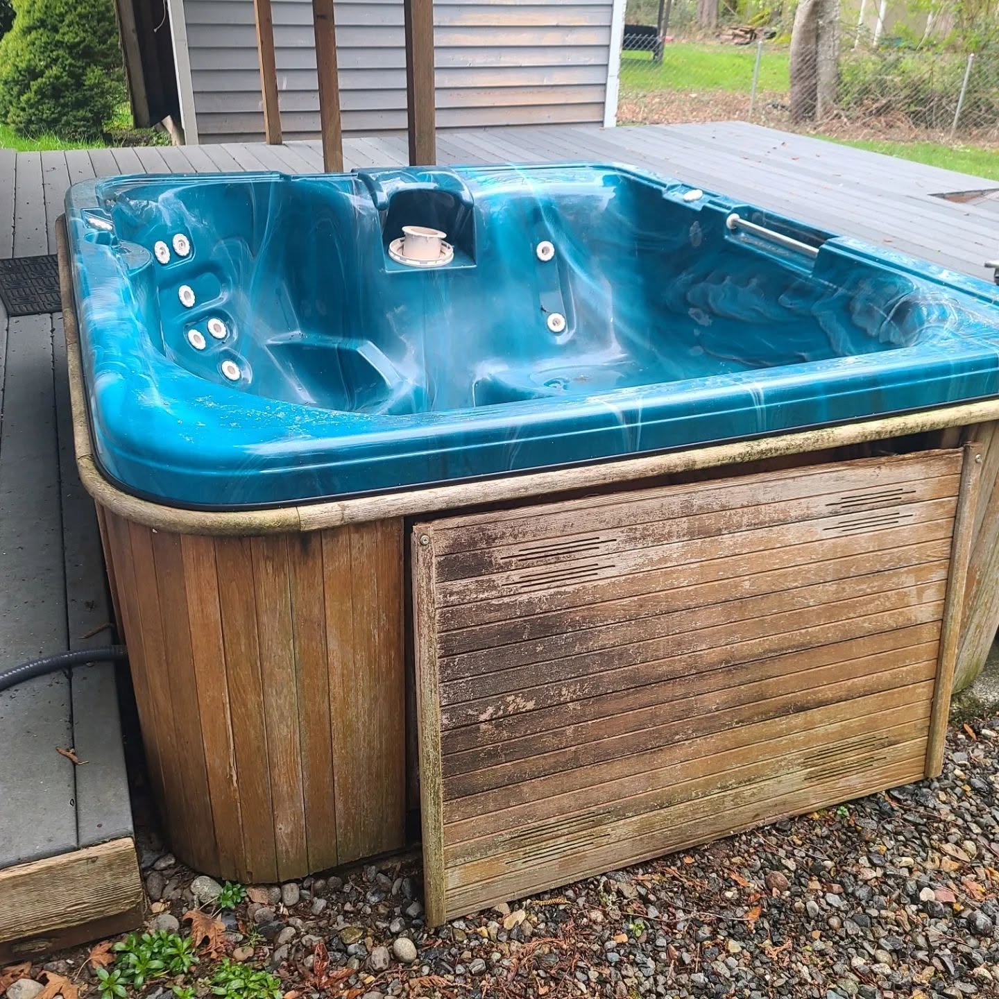 Old broken hot tub with lid being removed in Silverdale, Washington