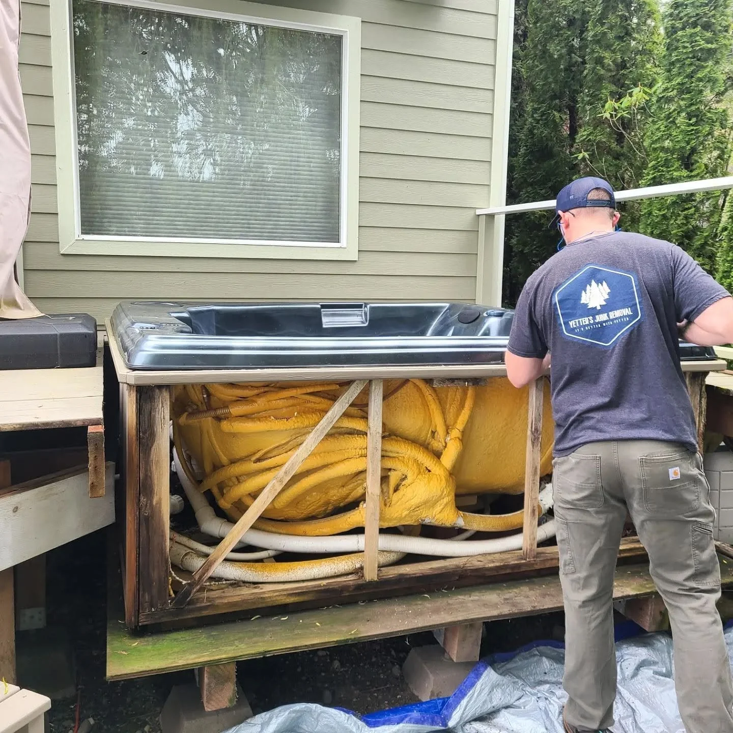 Mat Yetter, owner of Yetter's Junk Removal, breaking down an old hot tub in the back of a house in Gig Harbor