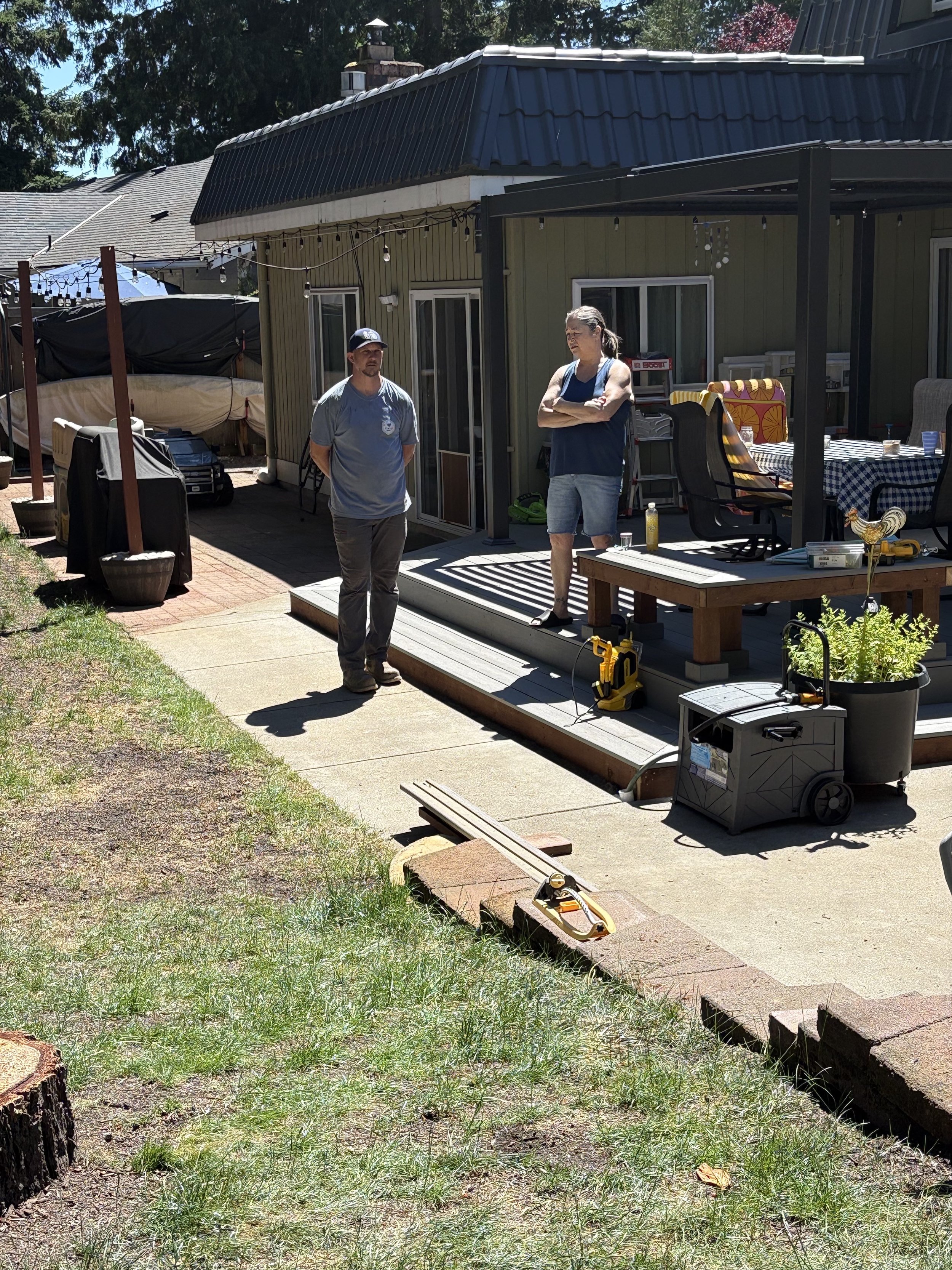 Owner of Yetter's Junk Removal standing on a back porch in front of a client's home, talking about their outdoor junk removal needs for their outdoor area.