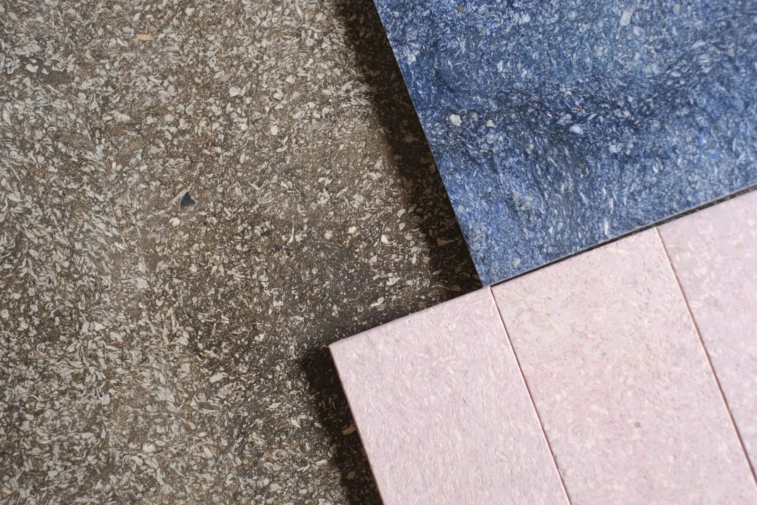Close-up of a tiled floor with pink, gray, and blue tiles.
