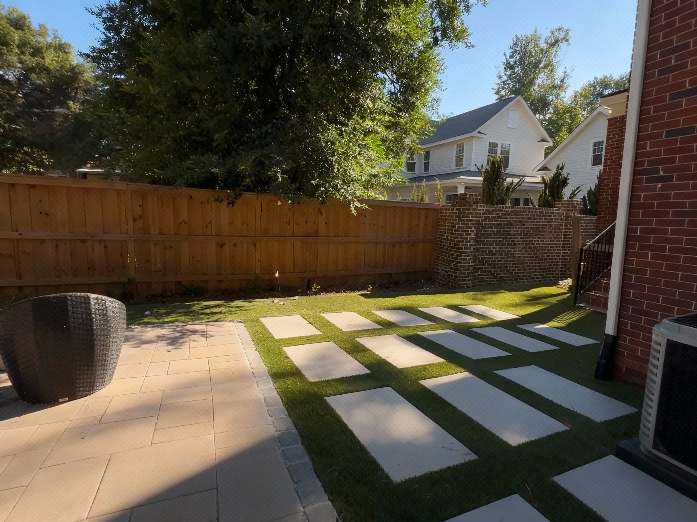 Concrete stepping stones with quality artificial turf installation in a persons backyard