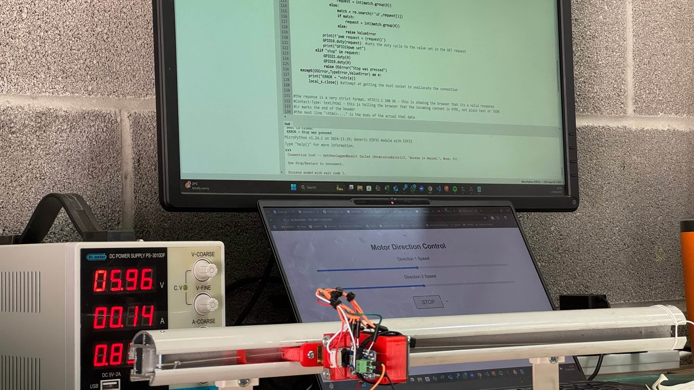 Workshop including a power unit and a prototype of an electric curtain track piece of mechanical hardware with the Python program running in the background