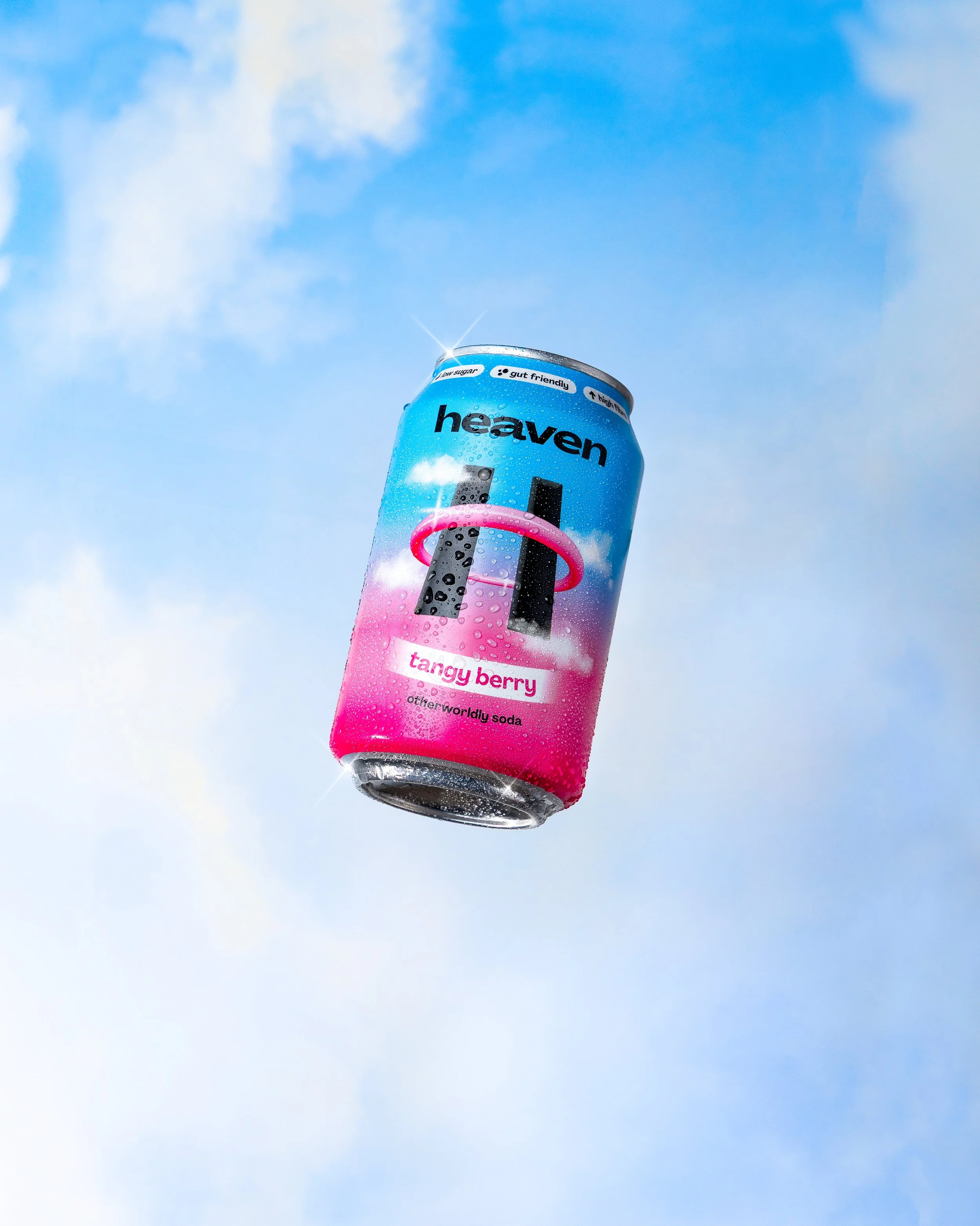 A can of heaven brand soda called tangy berry floating against a blue sky with clouds.