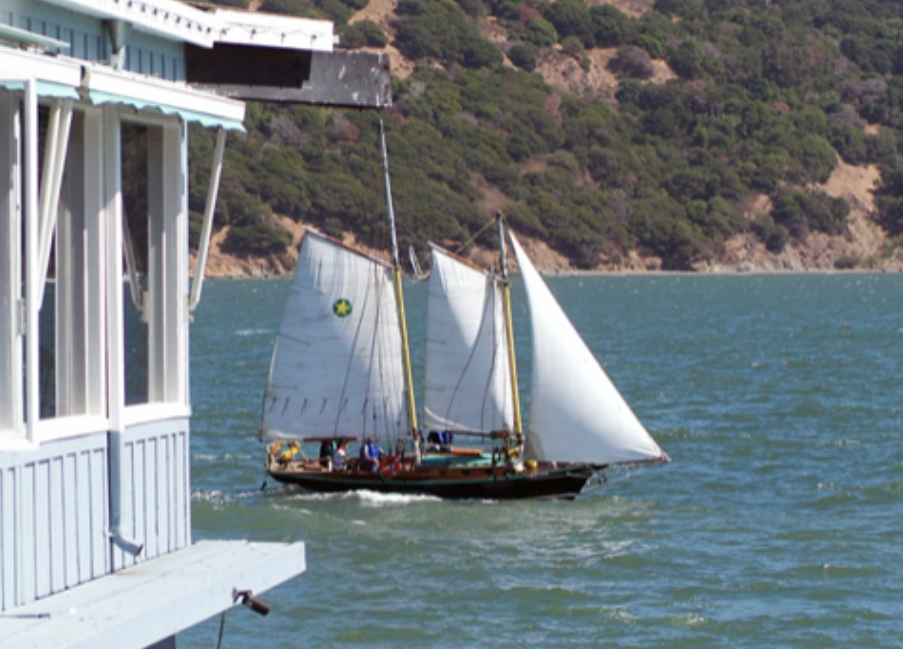 The smallest boat in the fleet, Stardust, sails past the Caprice restaurant. Mary Moseley and crew won the Spirit Award - a 15 year old bottle of rum. Photo ©2009 norcalsailing.com