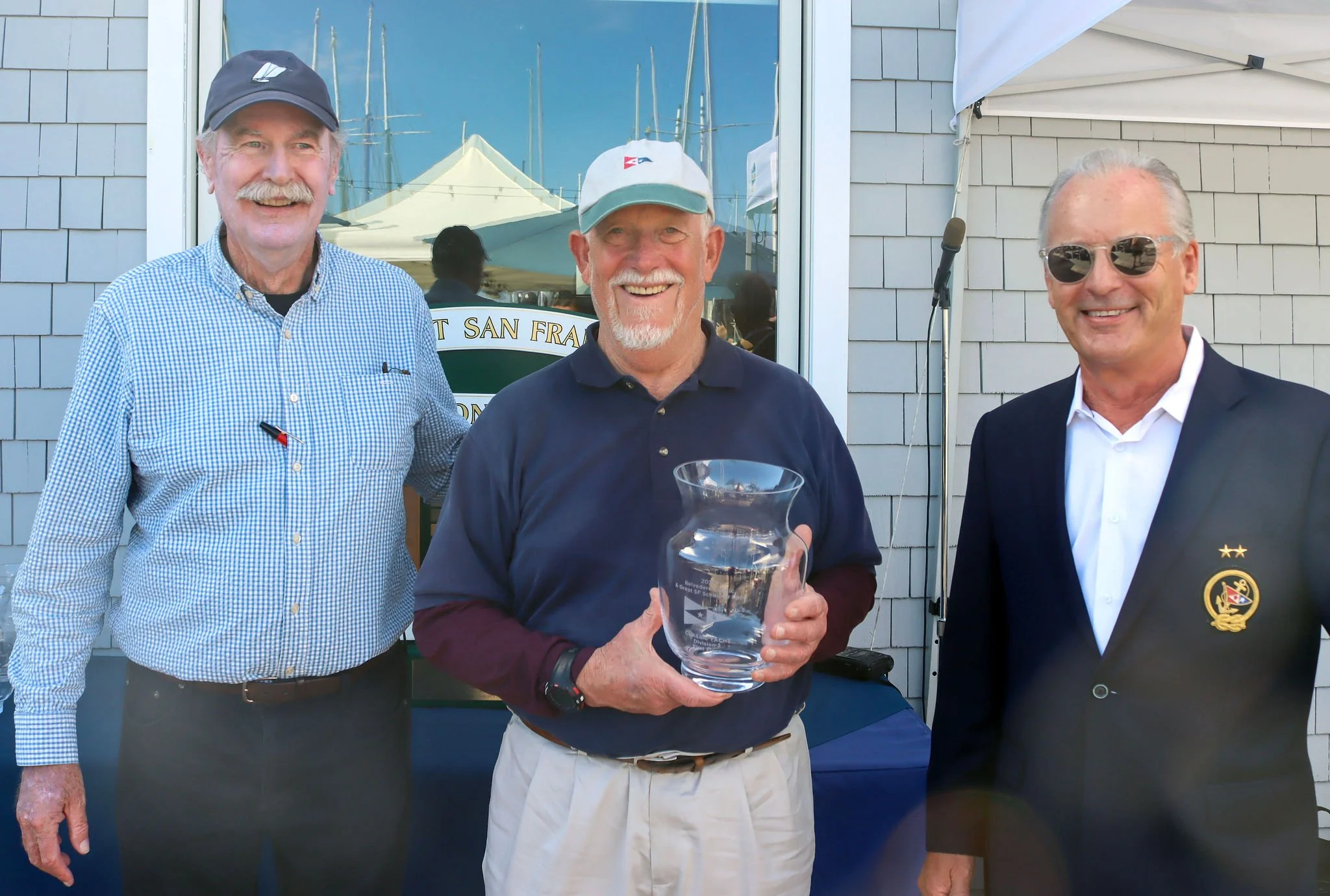 Carl Flemming, accepting on behalf of Bill Claussen for CUCKOO taking first place in Classics 2 division, with SFYC Staff Commodore John Swain and Vice Commodore Jeff Cusack.