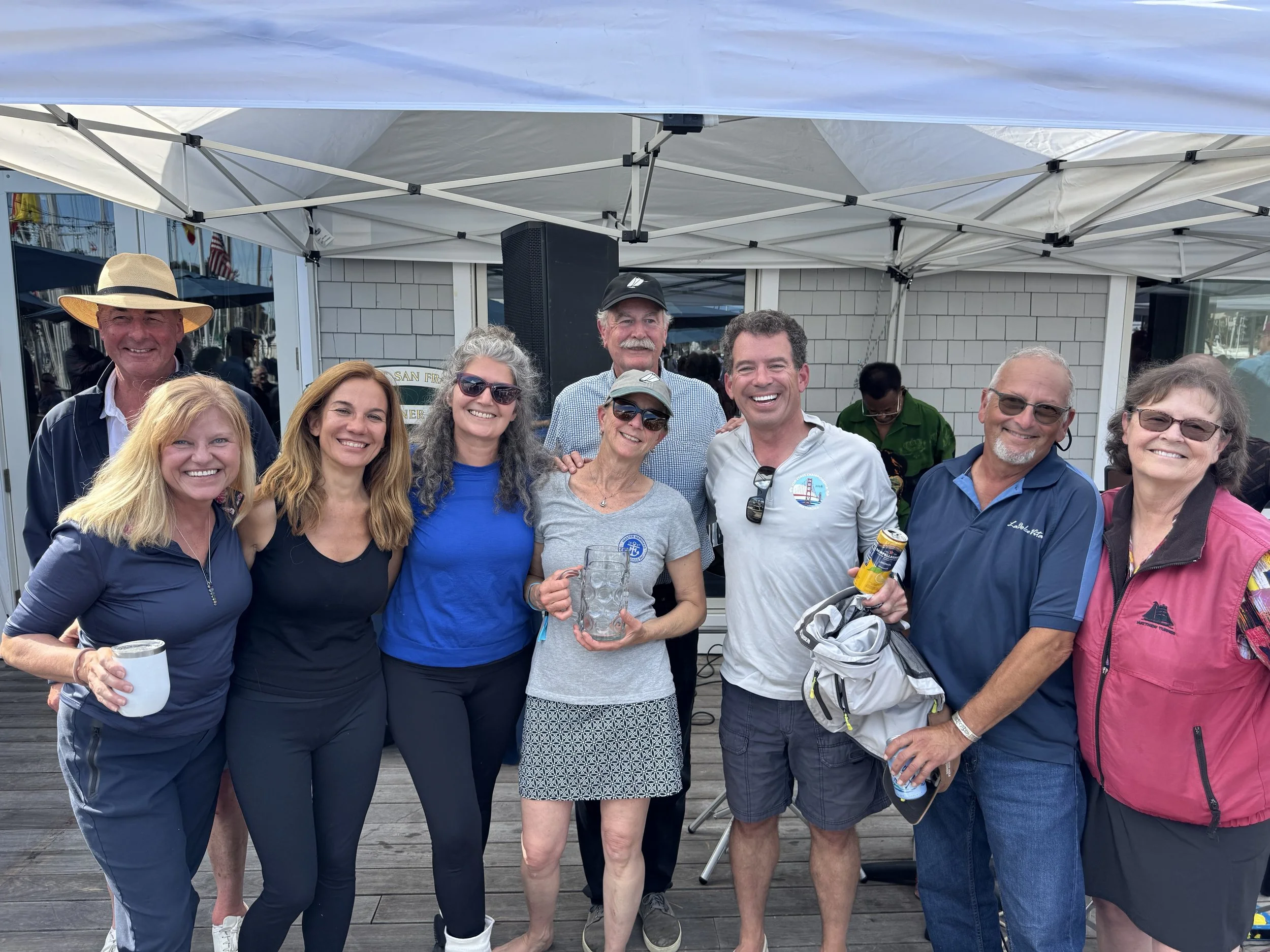 Sylvia and Barry Stompe, owners of Iolani, and crew receiving their 2nd place trophy for the Spirit of Tradition fleet from Jr. S/C Quentin Hill, S/C John Swain, and Angie Lackey, Co-Founder of the day's regattas.