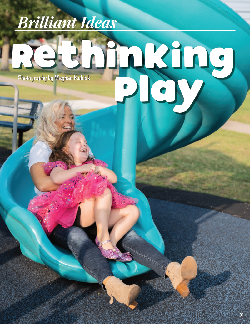 Woman and child sliding down a blue playground slide, smiling and enjoying playtime together.