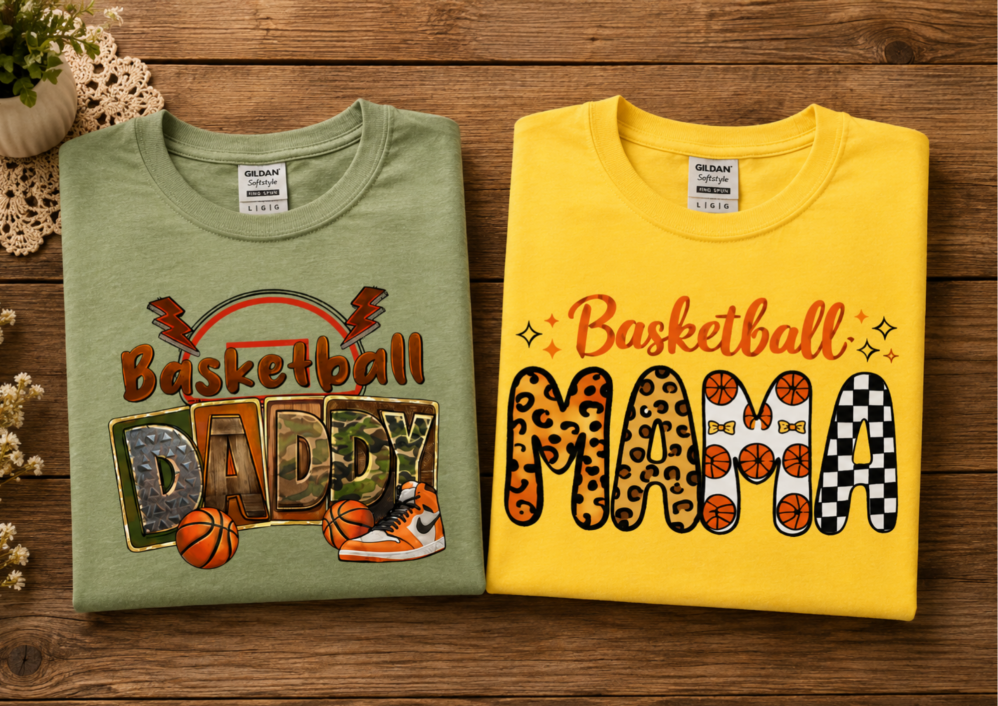 Two folded T-shirts on a wooden surface, one green with basketball-themed graphics and the other yellow with different patterned letters spelling 'MARCH', with flowers and a plant in a pot nearby.