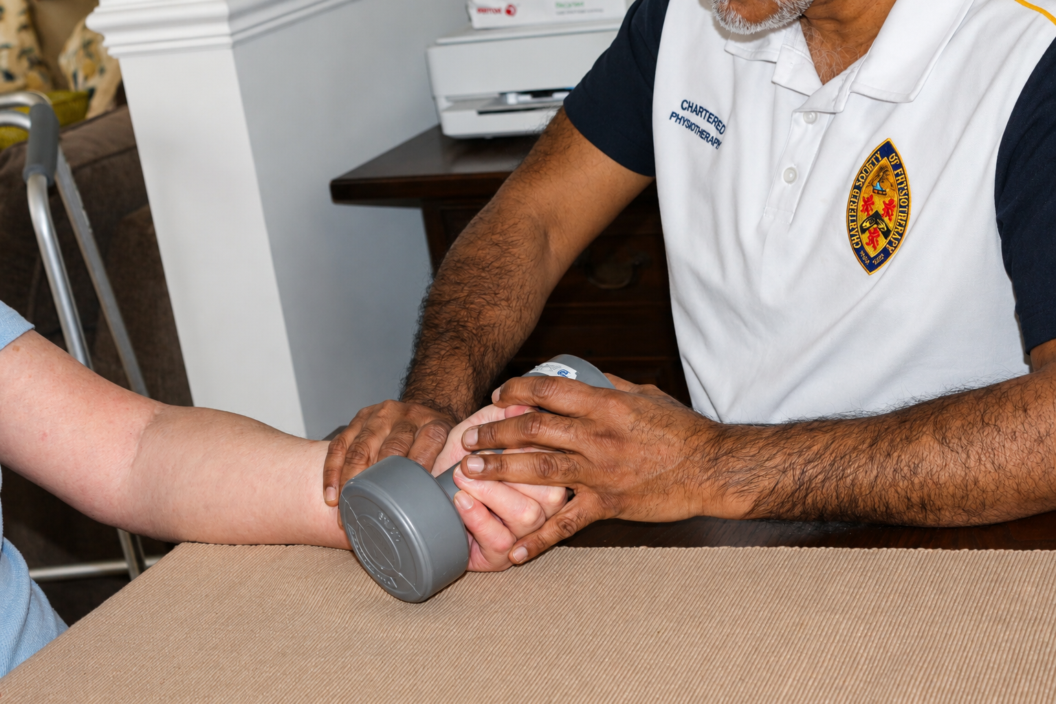 A physiotherapist is helping a patient with arm exercises using a handheld weight