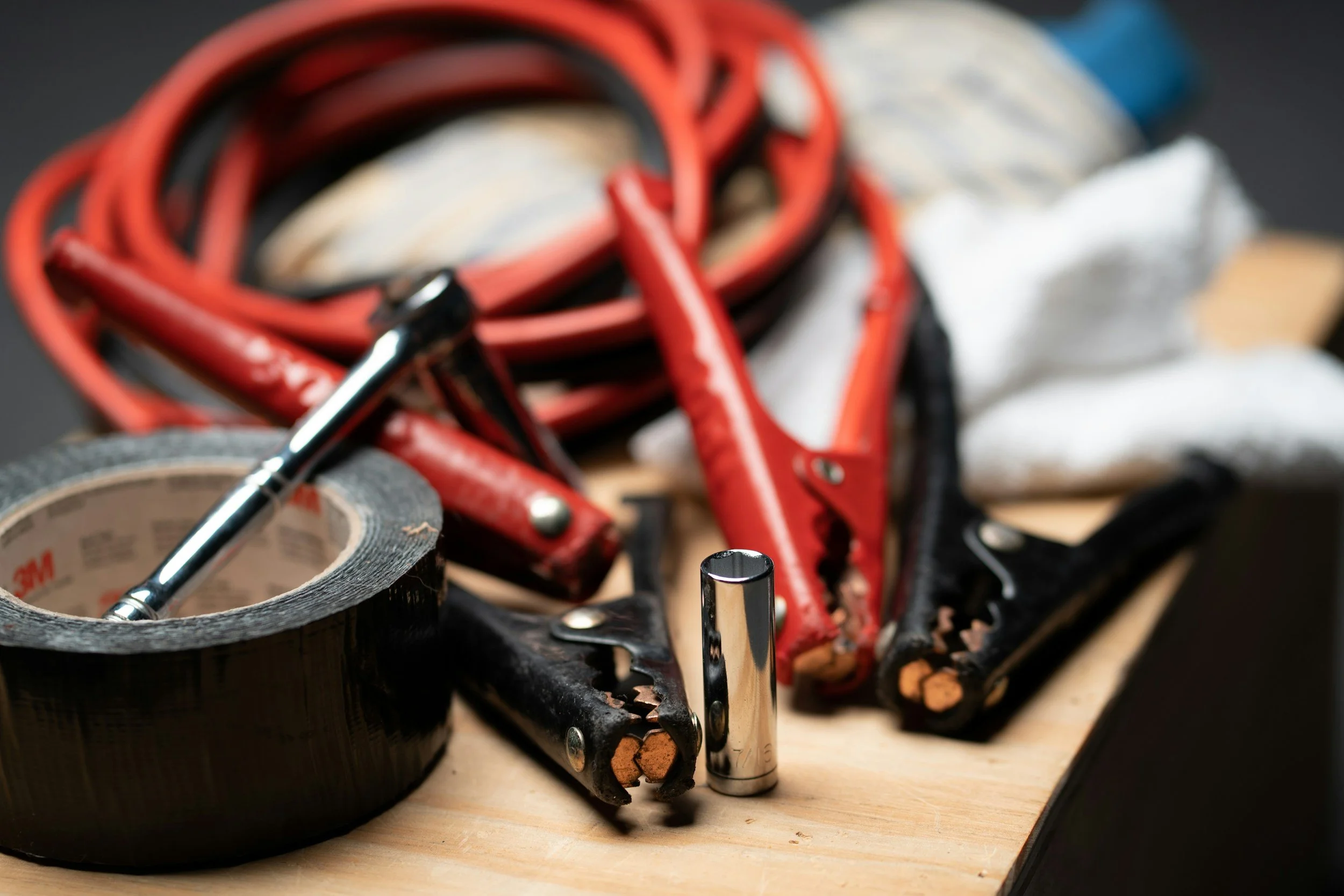 Car road trip emergency essentials including jumper cables and tire gauge